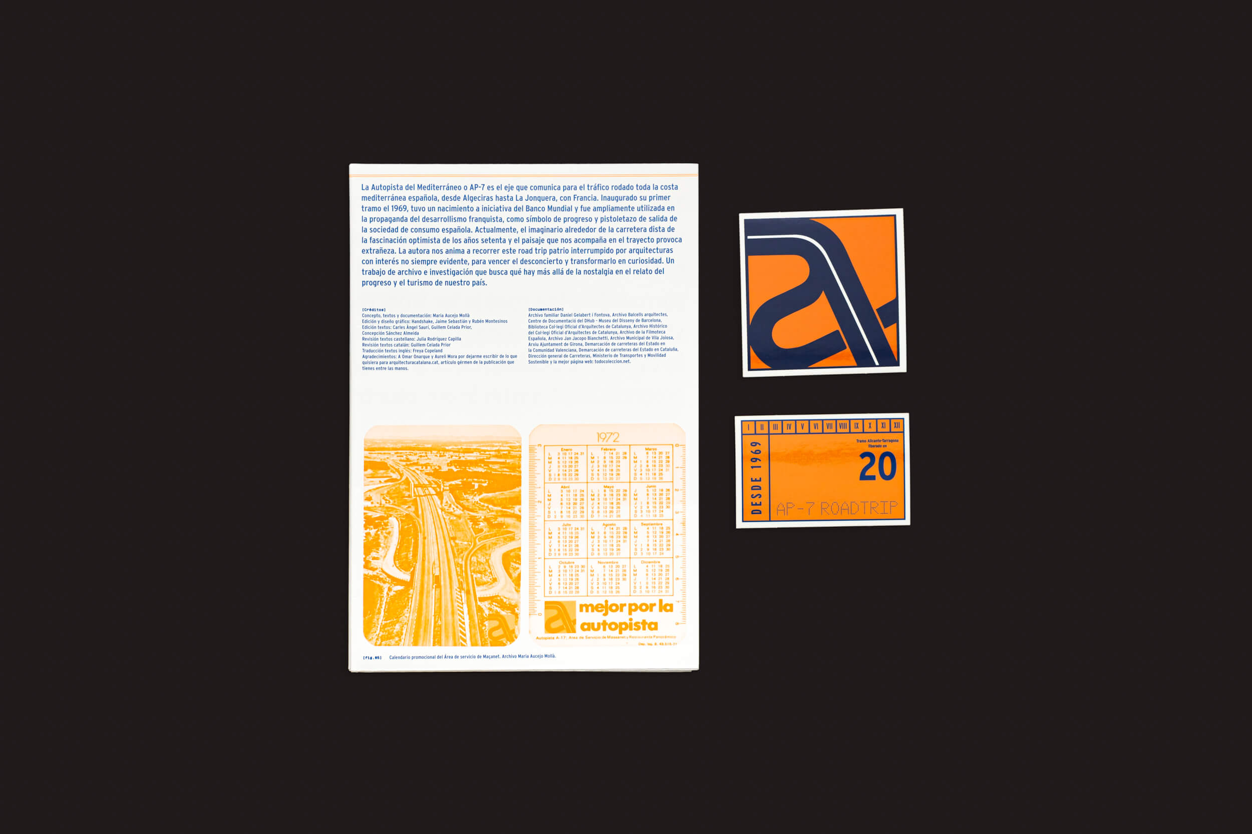 O Maria Aucejo: AP-7 Roadtrip da Handshake apresenta um pôster de rodovia com uma foto aérea da AP-7 em tons quentes de laranja, acompanhado de um adesivo laranja e um cartão de calendário retrô de 1972 com o logotipo autopiste em um fundo preto, capturando a essência da Autoestrada Mediterrânea da Espanha.