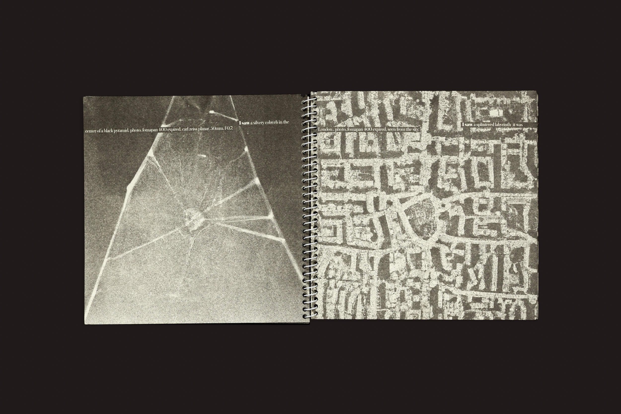 Um livro encadernado em espiral está aberto em duas páginas. A página da esquerda, aprimorada por IA, mostra uma imagem em tons de cinza de vidro rachado. A página da direita, com Aleph-2 de Juan Manuel Lara da SED Editorial, exibe um padrão abstrato semelhante a um labirinto contra um fundo preto.