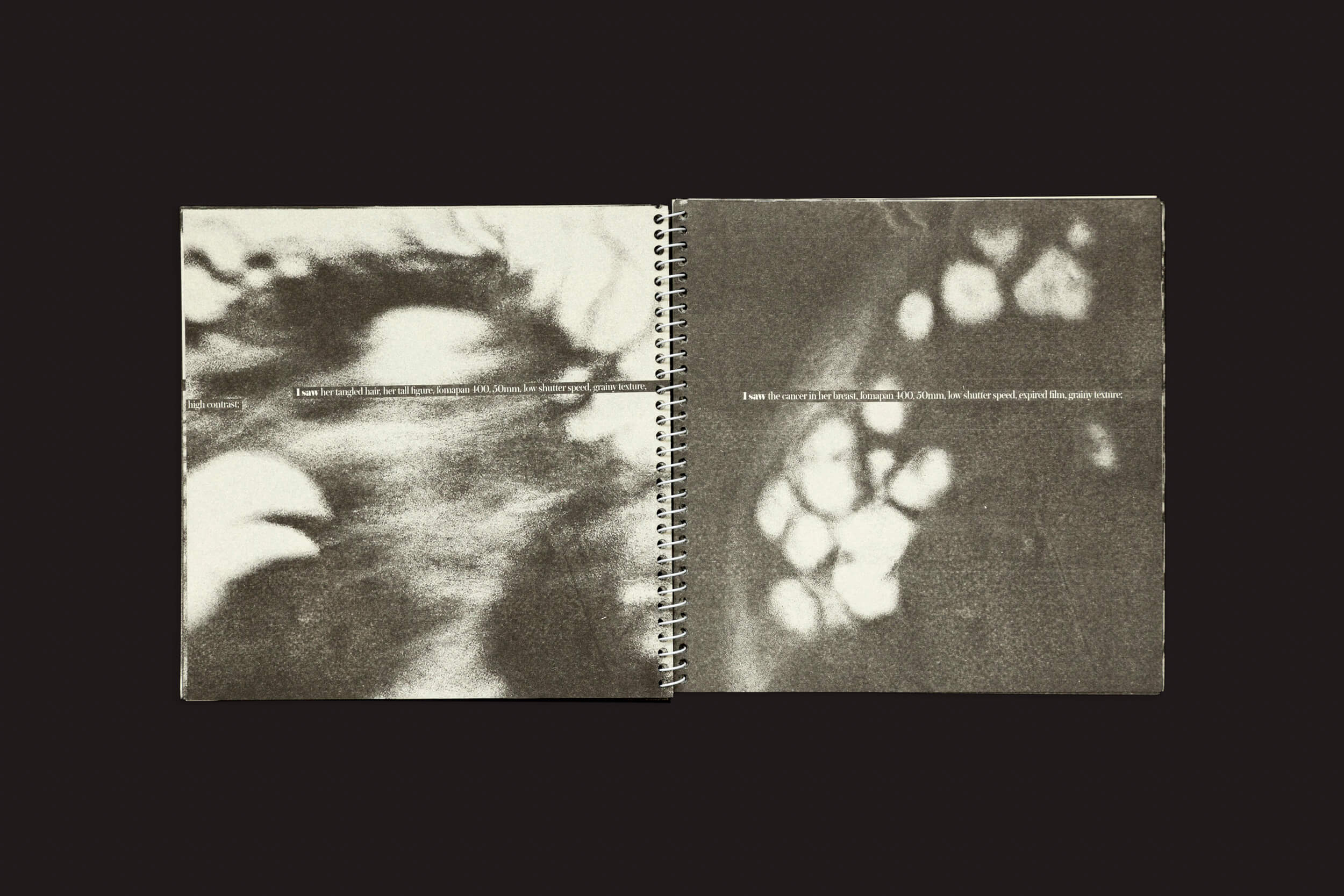 O livro encadernado em espiral Juan Manuel Lara: Aleph-2 da SED Editorial apresenta duas páginas de imagens abstratas em tons de cinza geradas por IA. A página da esquerda revela uma figura borrada, enquanto formas vagas aparecem na direita, com texto atravessando a dobra central contra um fundo escuro.