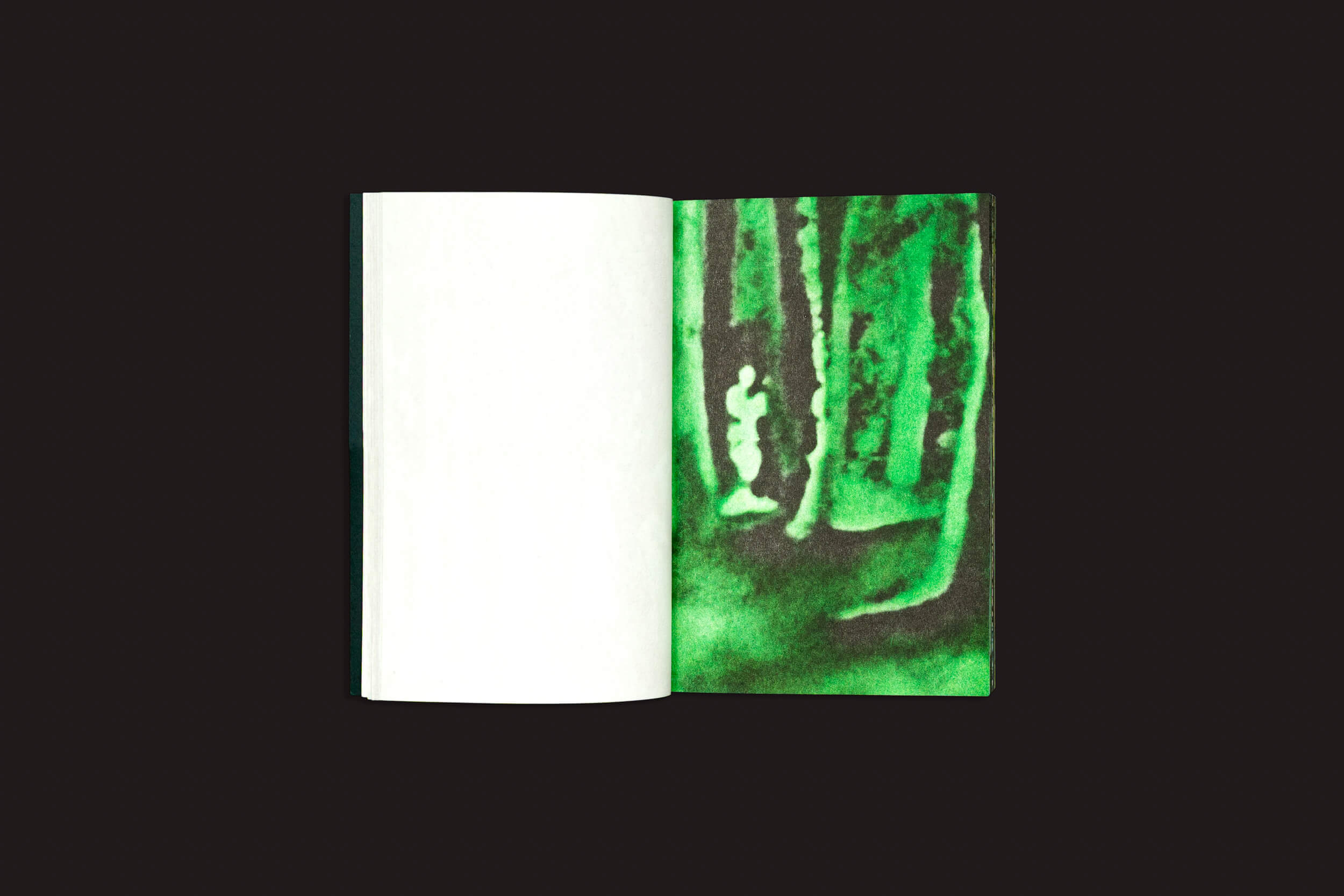 Um livro aberto, Pierre La Police: Another Green World, da Fidéle Editions, repousa sobre um fundo preto — página esquerda em branco, página direita com uma floresta verde em aquarela e uma silhueta branca — evocando uma conexão sensorial com livros de desenho.