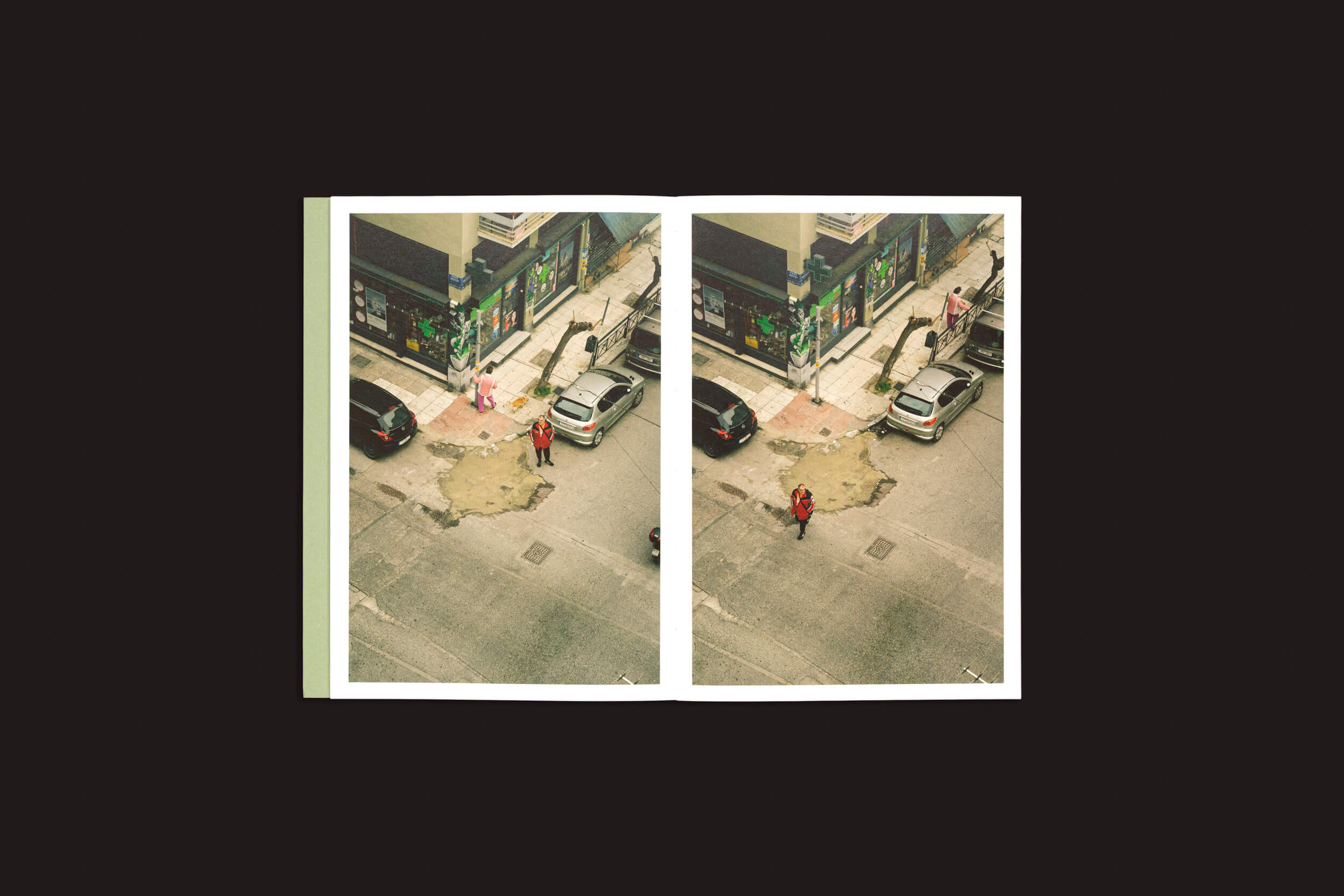 Simon Bray: Dear Kairos", de Skinnerboox, apresenta duas fotos aéreas lado a lado de uma esquina de Atenas com carros estacionados e uma pessoa de vermelho, adicionando vivacidade. O fundo escuro, evocativo do tempo grego, destaca a proeminência da cena.