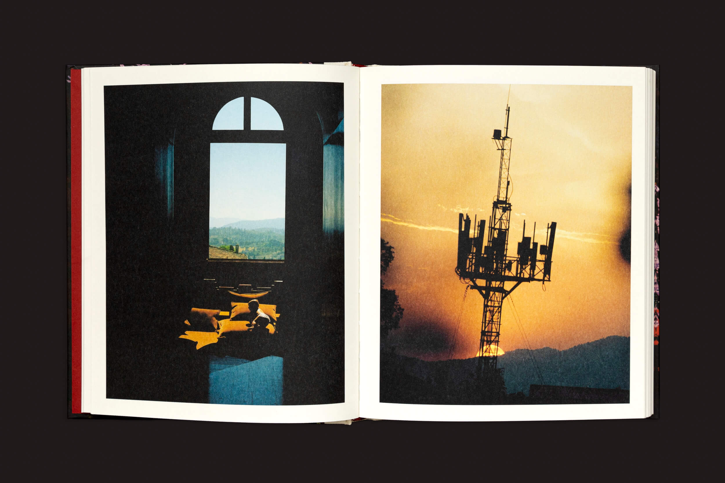 Em Pia Riverola: Días, de Loose Joints, um livro aberto exibe uma sala iluminada pelo sol com vista para as colinas à esquerda e uma torre de telecomunicações recortada contra o pôr do sol à direita, oferecendo uma experiência sensorial com imagens evocativas.