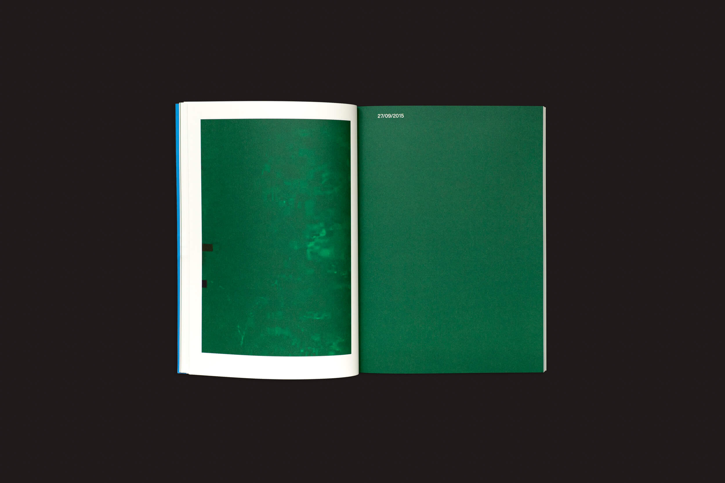 Um livro aberto da Loose Joints, Taysir Batniji: Disruptions, repousa sobre uma superfície escura. A página da esquerda apresenta uma imagem abstrata verde semelhante ao estilo de Batniji, enquanto a da direita é verde sólida com 07080785 no topo, ecoando sutilmente as disrupções.