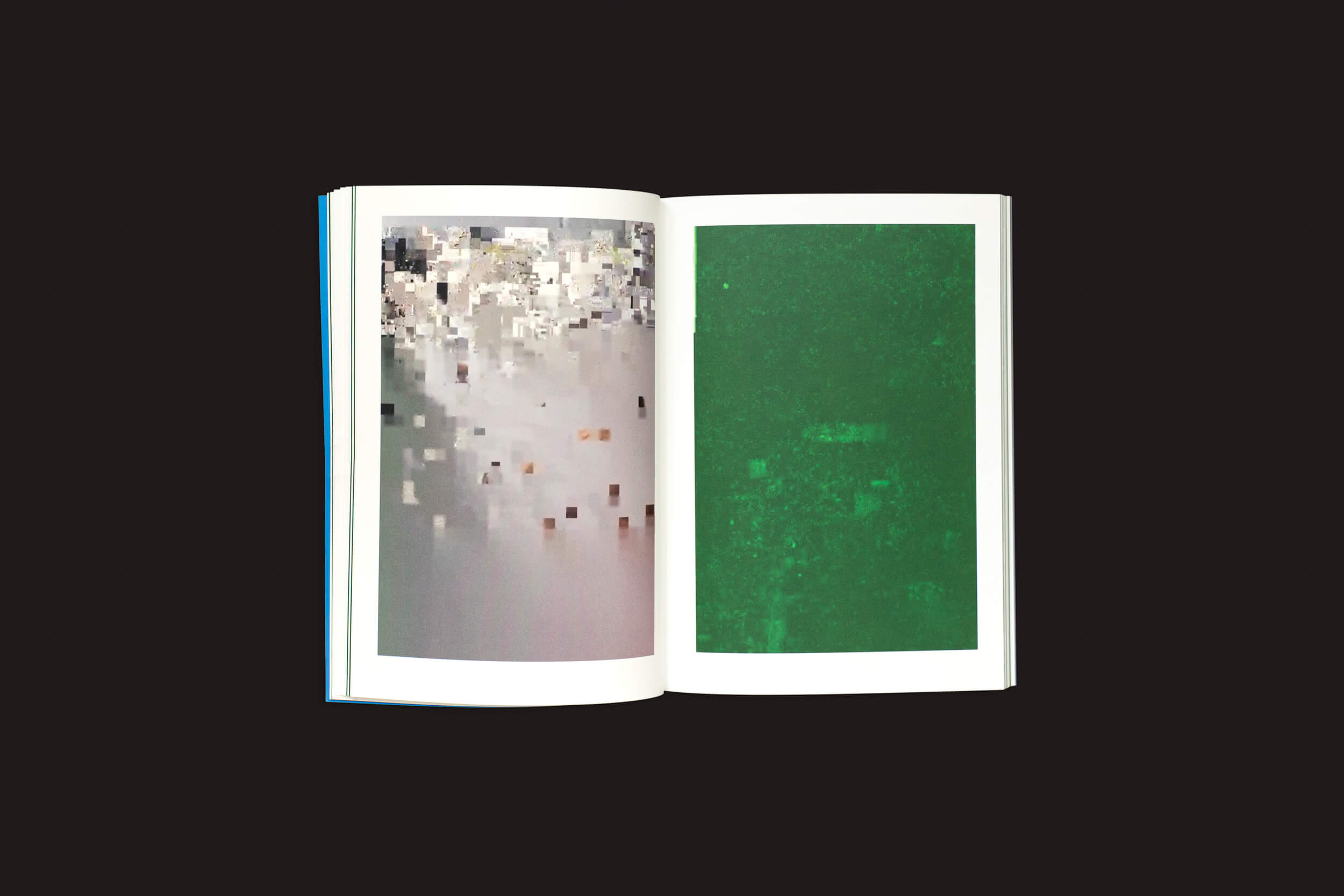 Um livro aberto revela duas páginas abstratas pixeladas: a esquerda mistura tons claros como bege, branco e cinza claro, e a direita é principalmente verde com sutis mudanças de pixel — ecoando o estilo de Taysir Batniji. O fundo é escuro. Produto: Taysir Batniji: Disruptions by Loose Joints.