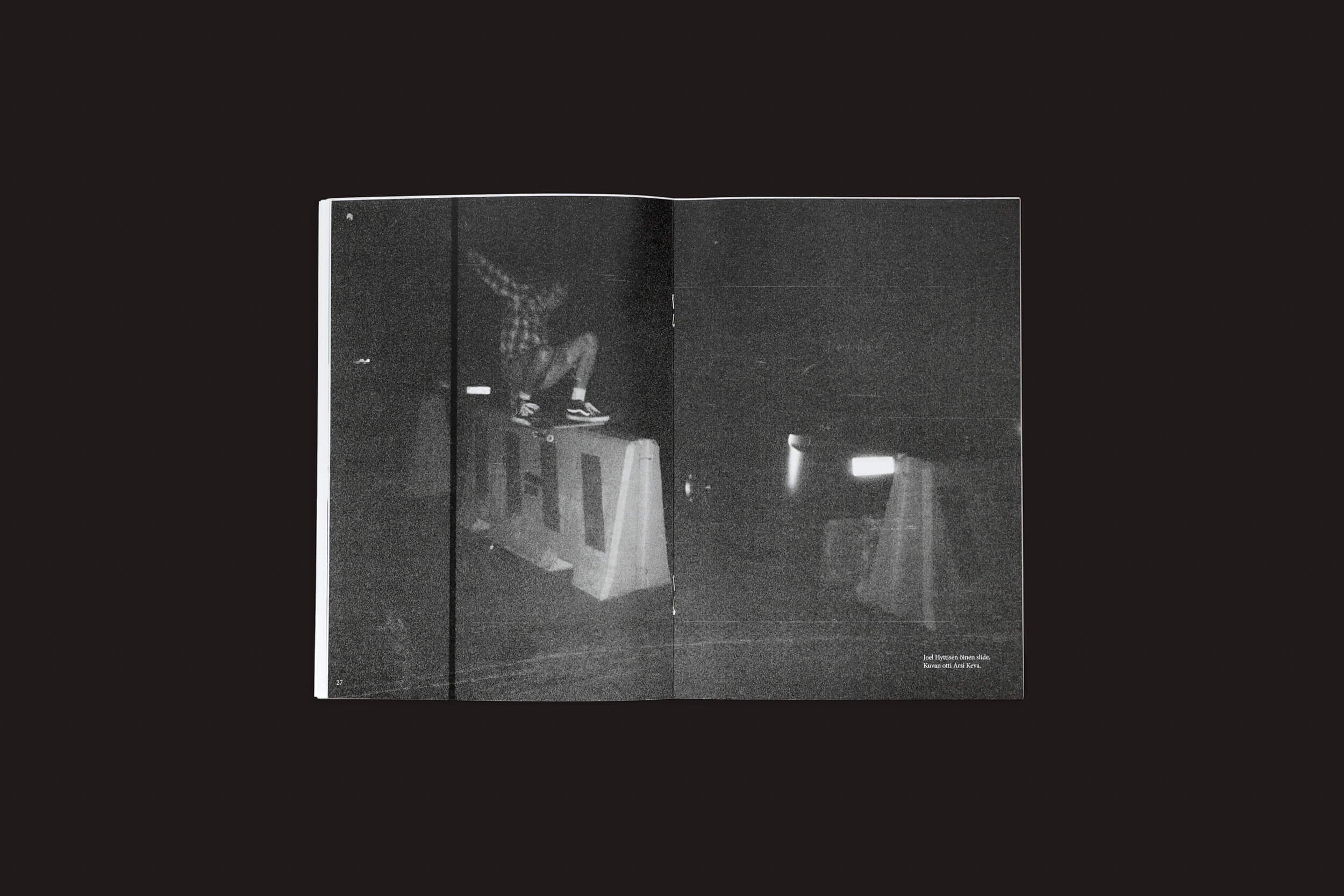 Uma foto em preto e branco na revista Edistyksen Voima #9: v/a do Ultraääni mostra uma pessoa andando de skate em cima de uma barreira de concreto à noite, com movimento borrado e pouca iluminação criando uma atmosfera sombria.