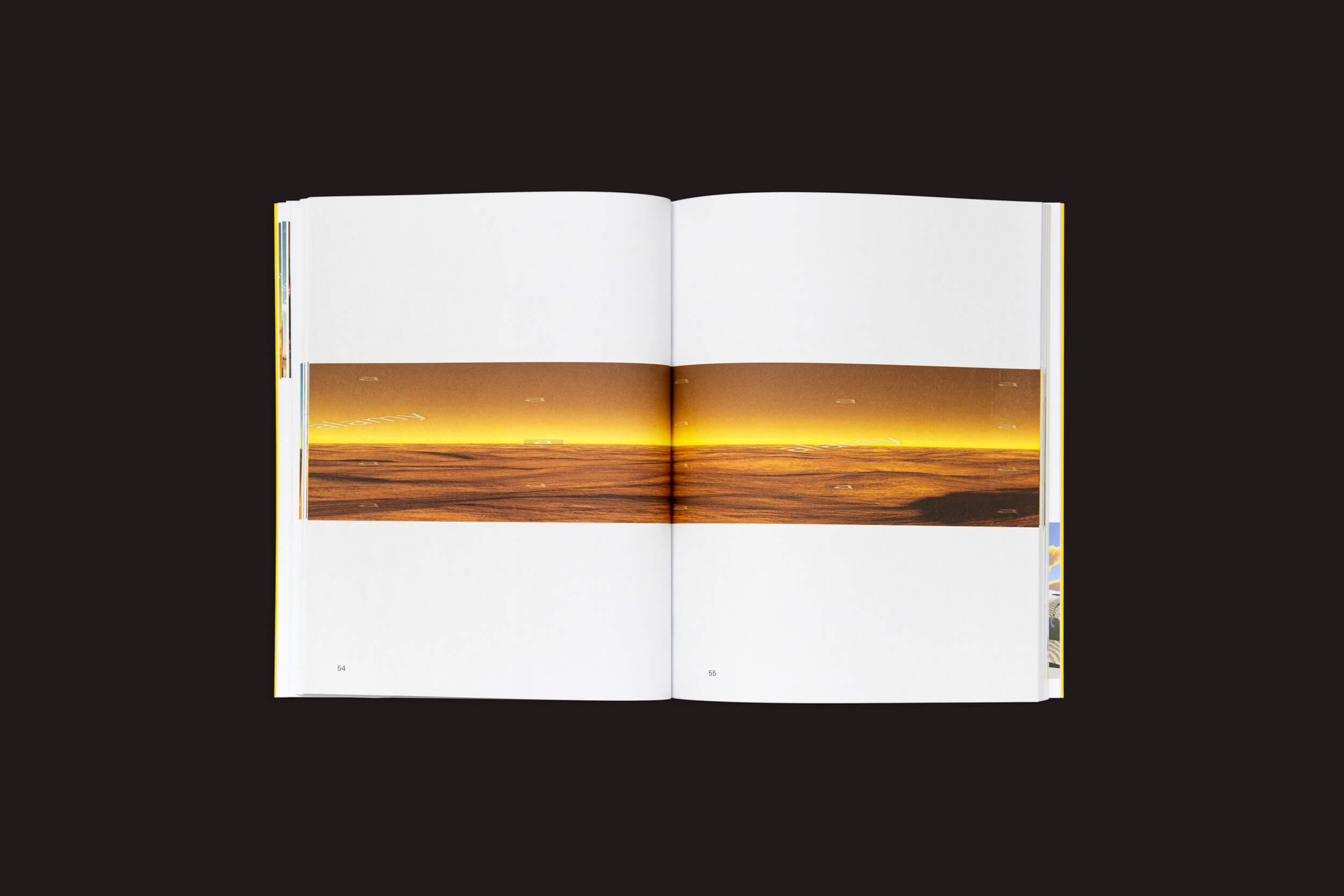 Um livro aberto intitulado Martín Bollati: El mundo es un tubo da SED Editorial, sobre um fundo preto, revela uma foto panorâmica de uma paisagem dourada, semelhante a um deserto, que se estende por duas páginas, com indícios da vastidão do Oceano Atlântico se fundindo à cena serena.