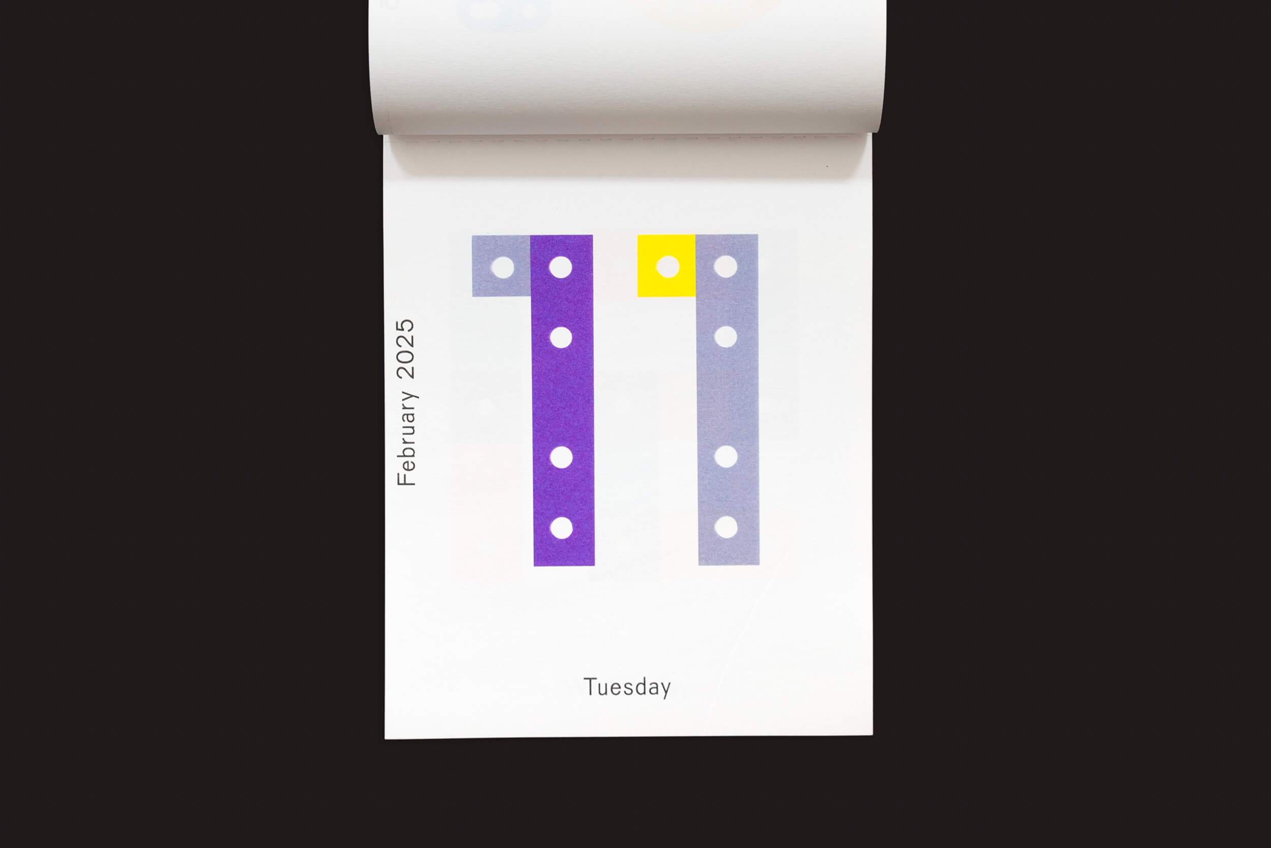 O Karel Martens: Calendário 2025 / Cada dia é um novo dia da Roma Publications apresenta um design minimalista para 11 de fevereiro de 2025, terça-feira, com colunas verticais de pontos roxos e azuis e um único ponto amarelo no canto superior direito.