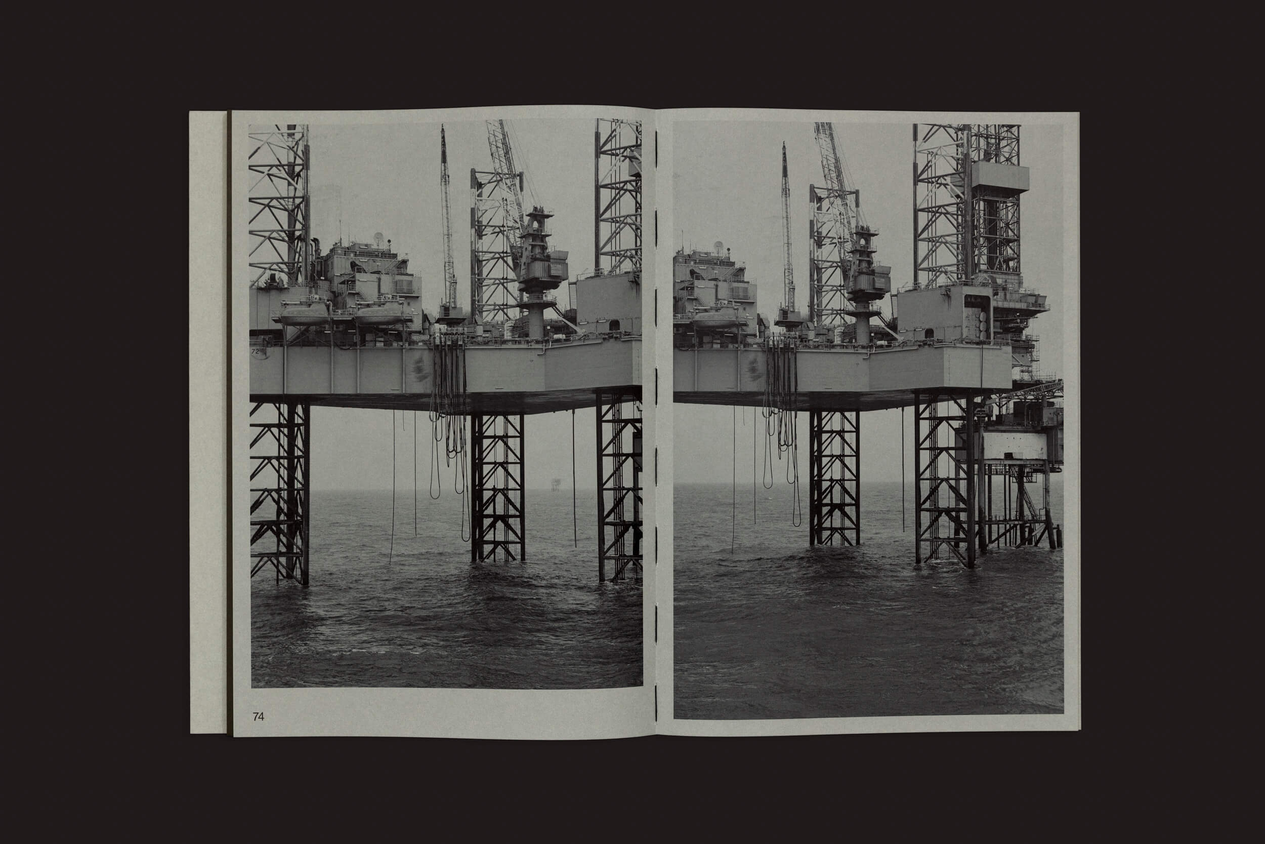O livro Forgotten Seas, de Tanja Engelberts, publicado pela The Eriskay Connection, mostra uma foto em preto e branco de uma plataforma de petróleo offshore com vários níveis e guindastes em frente ao mar, destacando a vastidão da indústria de petróleo e gás.