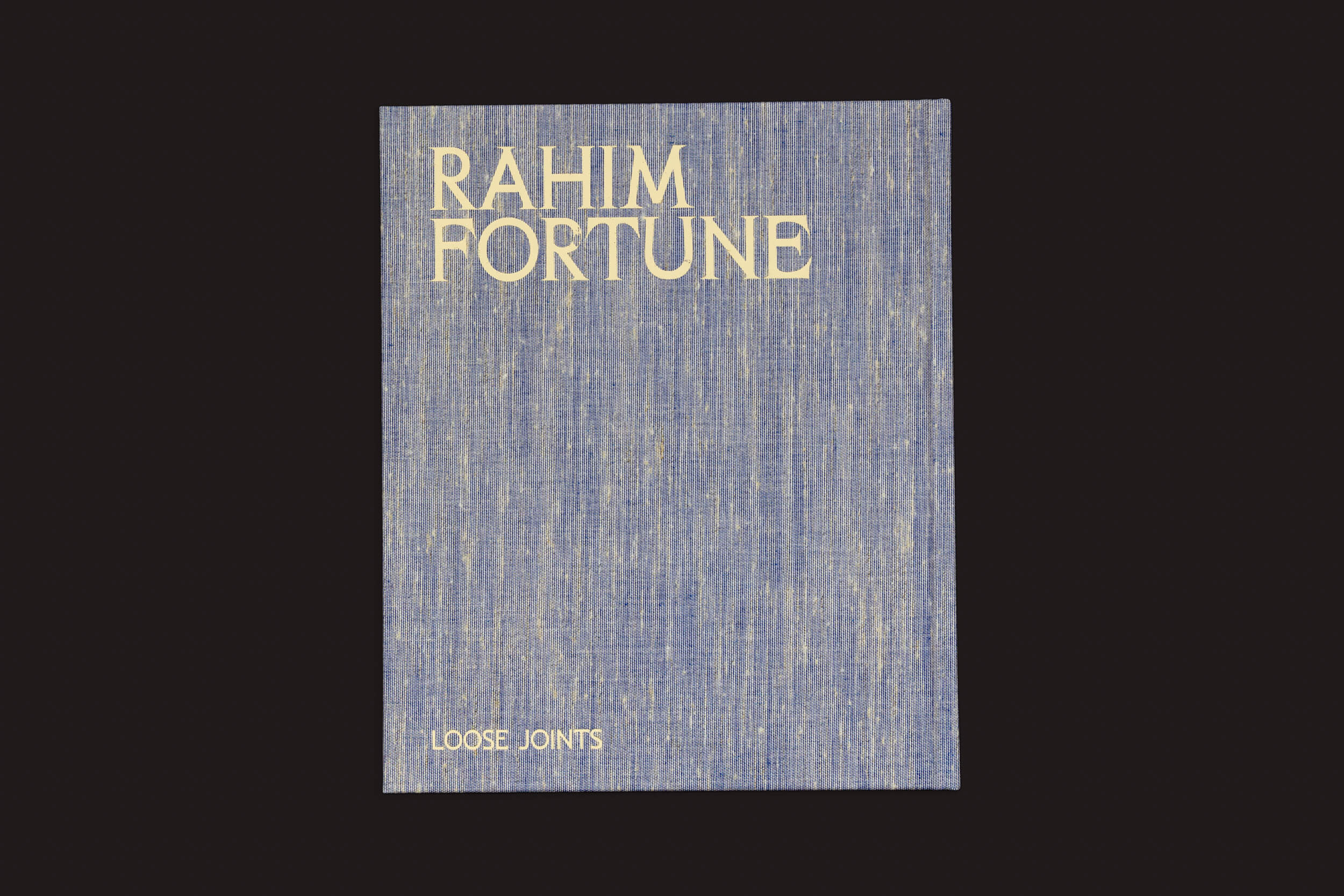 Uma capa de livro azul texturizada exibe RAHIM FORTUNE em creme na parte superior e LOOSE JOINTS na parte inferior contra um fundo preto sólido, evocando a América pós-emancipação. O produto é intitulado Rahim Fortune: Hardtack by Loose Joints.