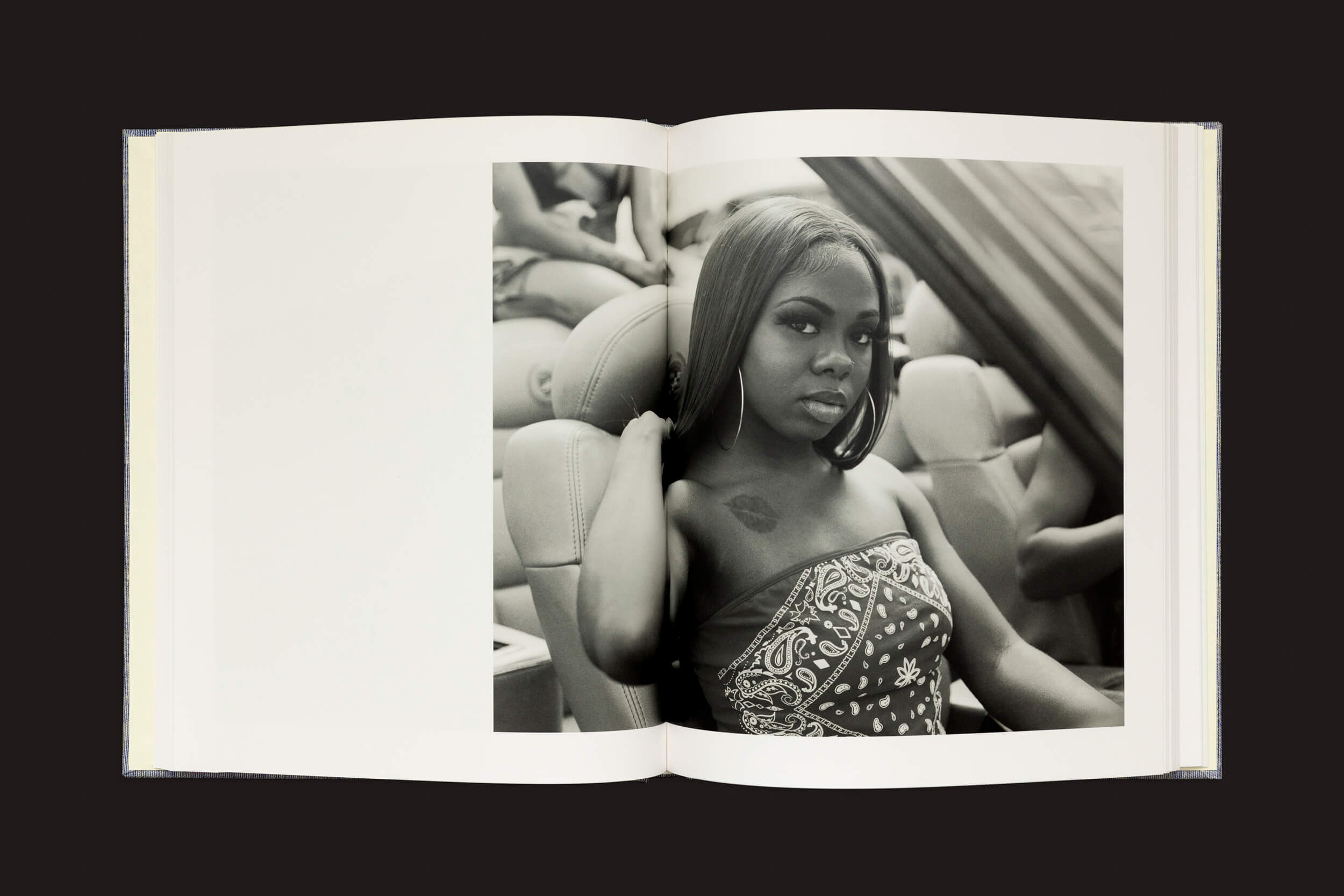 O livro aberto Rahim Fortune: Hardtack da Loose Joints traz uma fotografia em preto e branco de uma mulher em um carro, simbolizando a América pós-emancipação. Com cabelos longos, brincos de argola e um top sem alças estampado, ela apoia a mão direita no encosto de cabeça enquanto olha para a câmera.