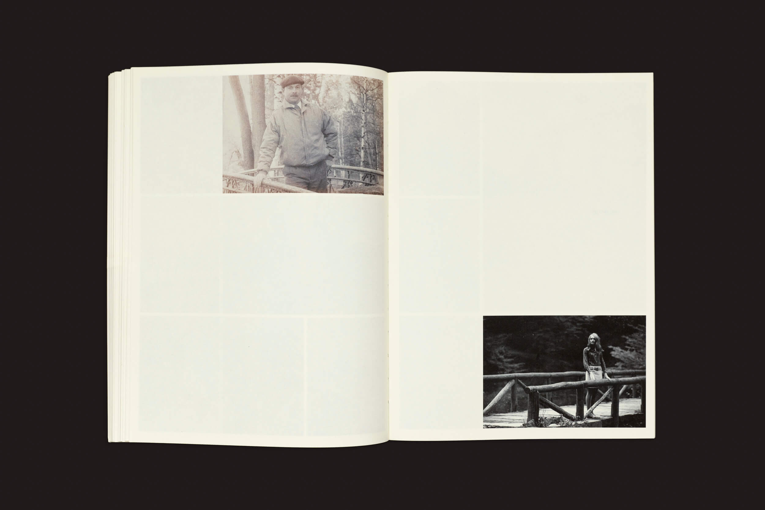 No livro aberto, uma foto em preto e branco de uma pessoa em uma ponte de madeira aparece no canto superior esquerdo, com outra no canto inferior direito. O resto, como "Incomplete Encyclopedia of Touch: Erik Kessels, Thomas Sauvin, Karel De Mulder" da RVB Books, está em branco contra o fundo preto profundo.