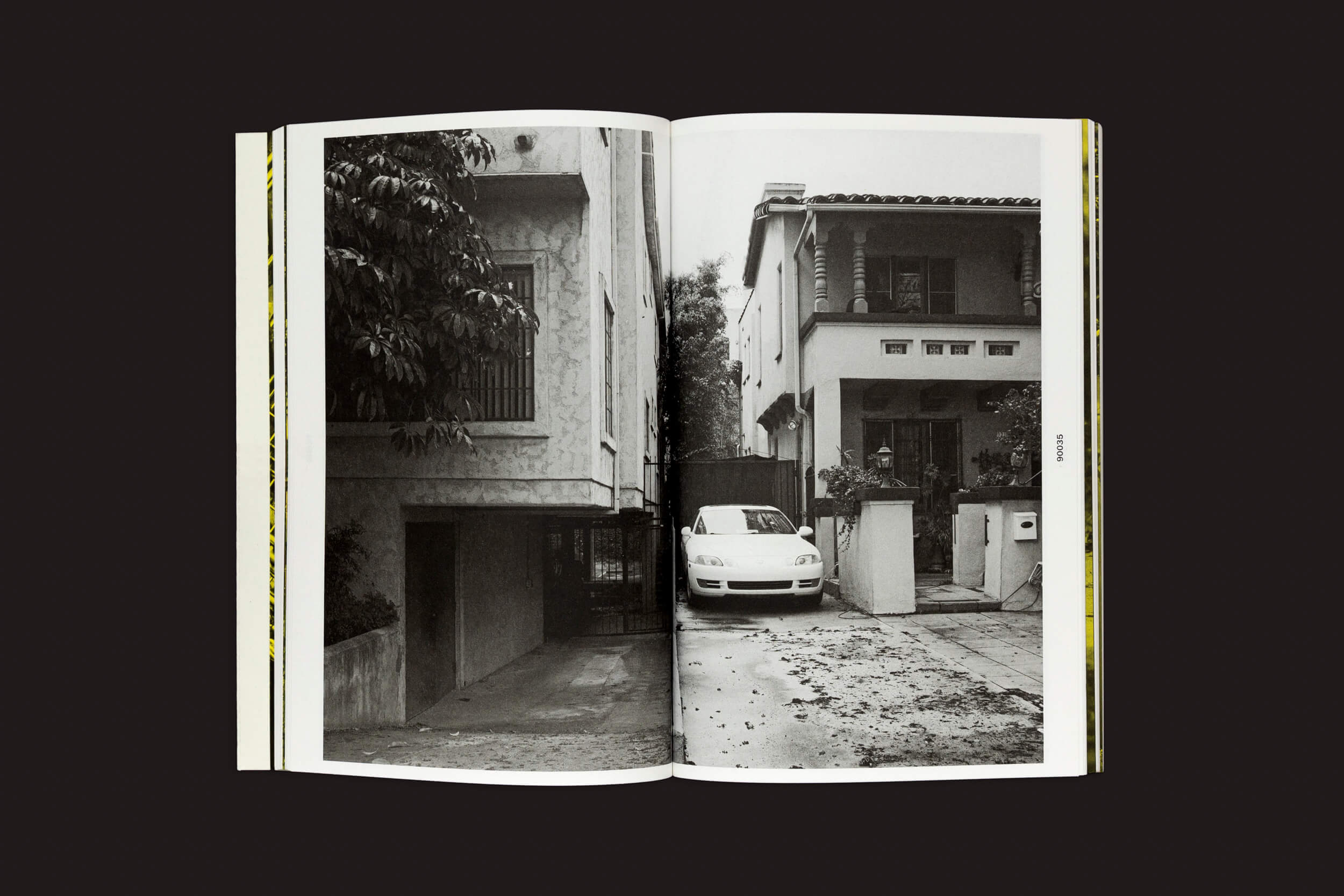 O Eriskay Connection apresenta Thomas Locke Hobbs: L.A. Vedute, com fotos em preto e branco de um beco estreito perto de um prédio e um carro branco estacionado em frente a uma casa adornada com árvores e folhas espalhadas, capturando a arquitetura doméstica por excelência.