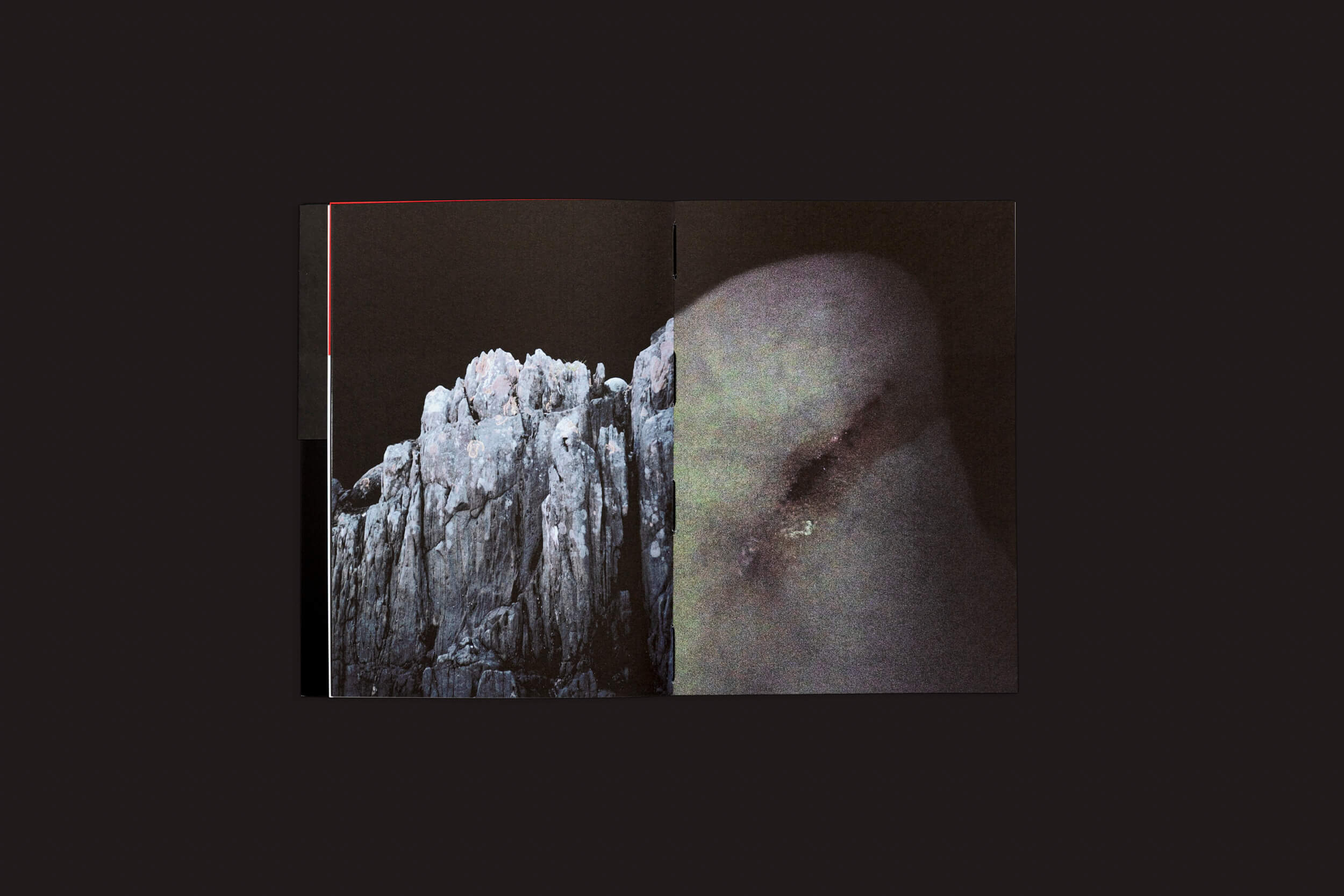 O livro Claudio Albarrán Briso: La herida del hombre, da SED Editorial, apresenta um penhasco rochoso sob um céu escuro em uma página e um close-up de uma superfície lisa e sombreada na outra, evocando encontros simbólicos com a arte da natureza contra um fundo simples e escuro.