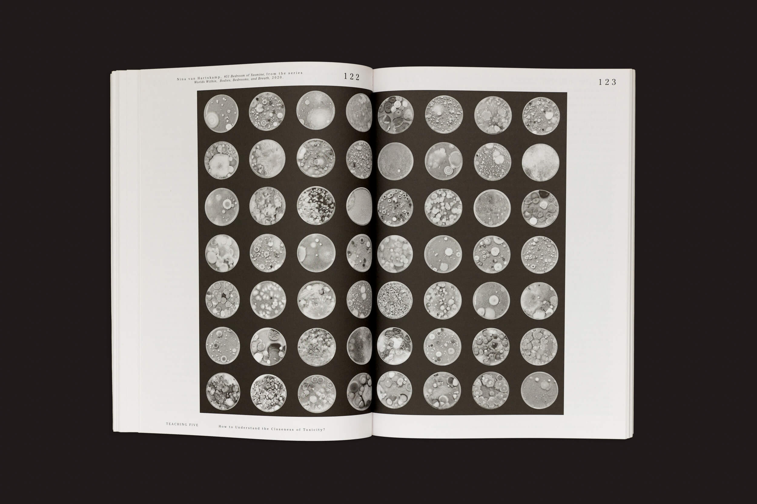 Um livro aberto, "Let’s Become Fungal! - Mycelial Learning and the Arts" de Yasmine Ostendorf-Rodríguez de Valiz, revela as páginas 122-123 com uma grade de fotos circulares em preto e branco. Essas imagens lembram padrões fúngicos, evocando visões microscópicas ou arte abstrata contra um fundo escuro.