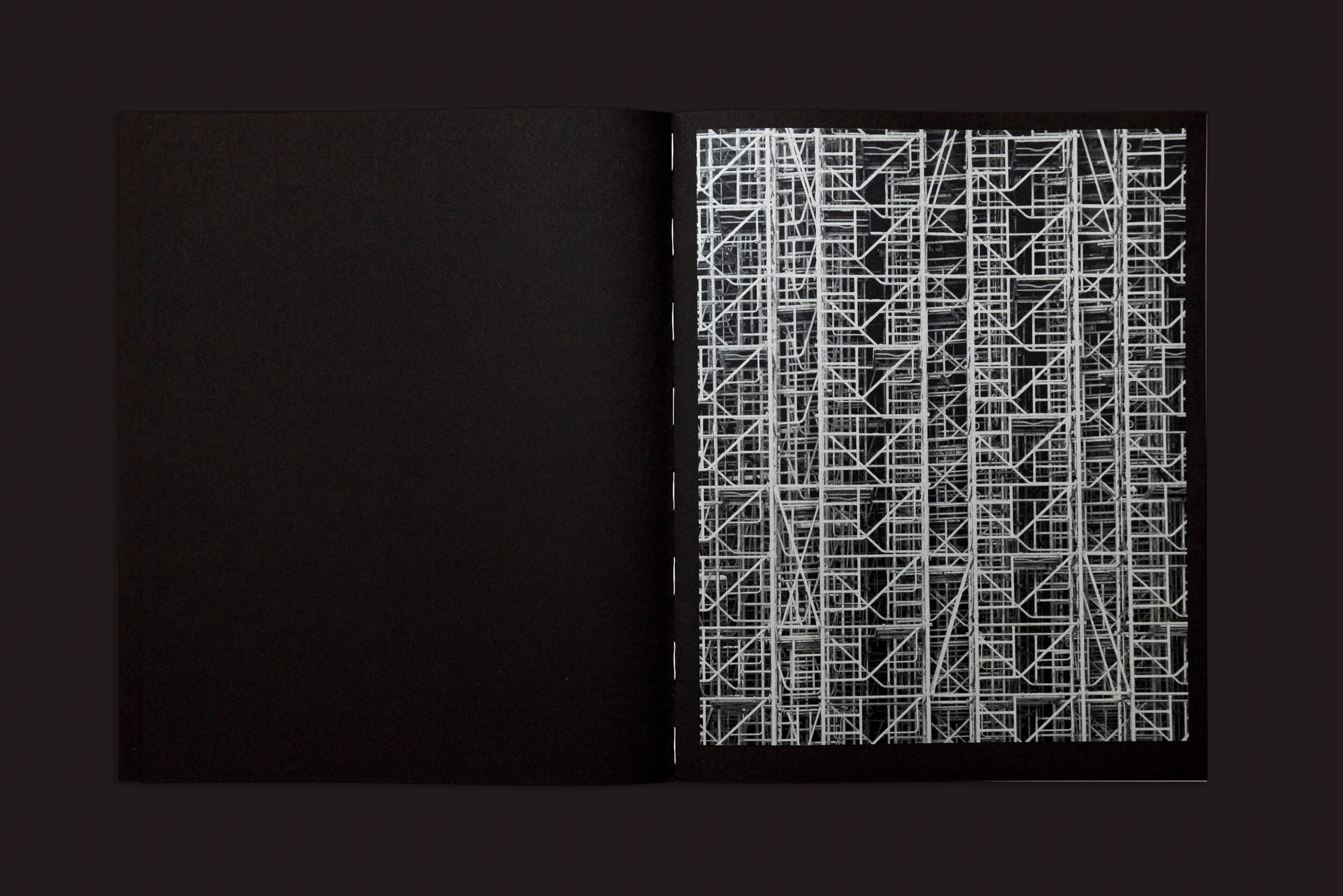 O livro aberto "Ezio D'Agostino: NEOS" de Skinnerboox mostra uma página preta à esquerda e uma página à direita com um padrão complexo e abstrato que lembra andaimes brancos em um fundo escuro, evocando as possibilidades complexas da mineração de asteroides dentro dos vastos Recursos Espaciais.