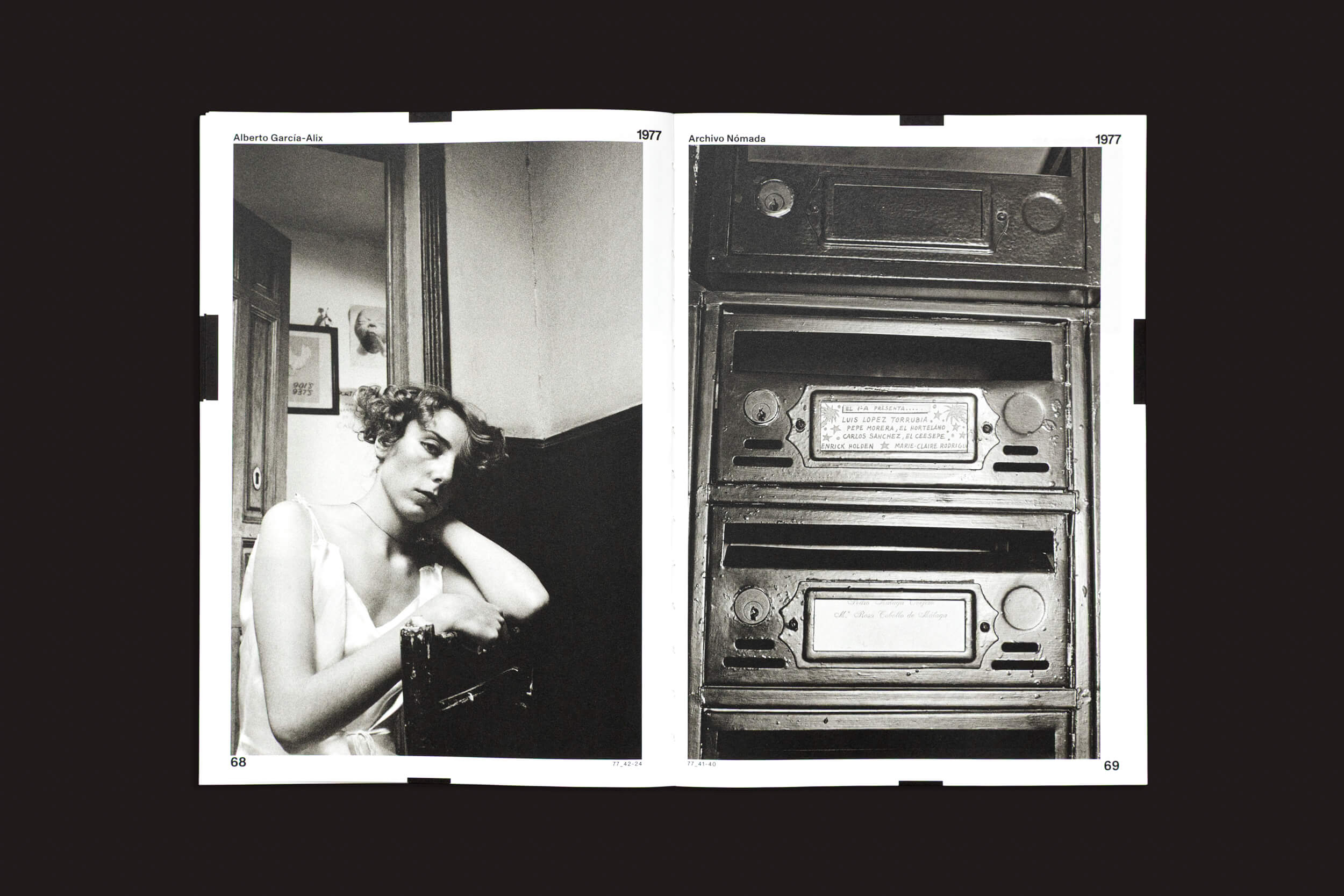 Em uma página dupla em preto e branco de "Alberto García-Alix: Arquivo Nômade 01", de Cabeza de Chorlito, uma mulher com um vestido leve senta-se pensativa na página da esquerda, lembrando uma musa de Alberto García-Alix. Caixas de correio vintage com placas decorativas adornam a página da direita, ecoando a fotografia espanhola.