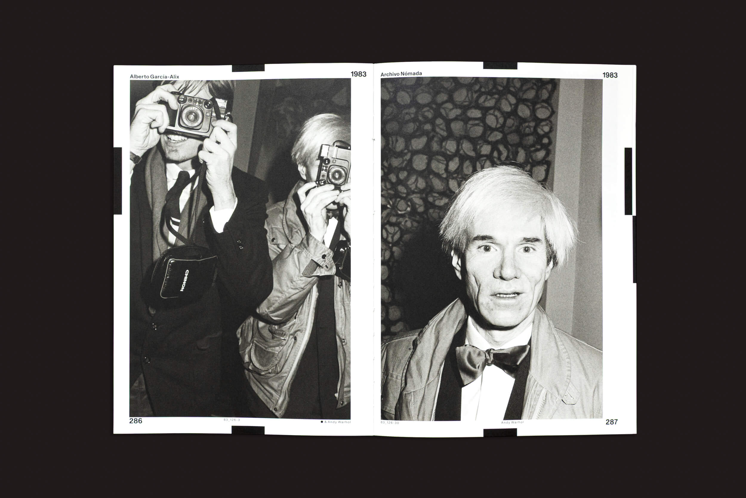 Uma página dupla de "Alberto García-Alix: Arquivo Nômade 02", de Cabeza de Chorlito, exibe fotos em preto e branco de um homem de cabelos claros. À esquerda, ele cobre o rosto com uma câmera; à direita, usa uma gravata borboleta e olha para a frente. Datas e nomes, como "Alberto García-Alix", adornam os cantos superiores.