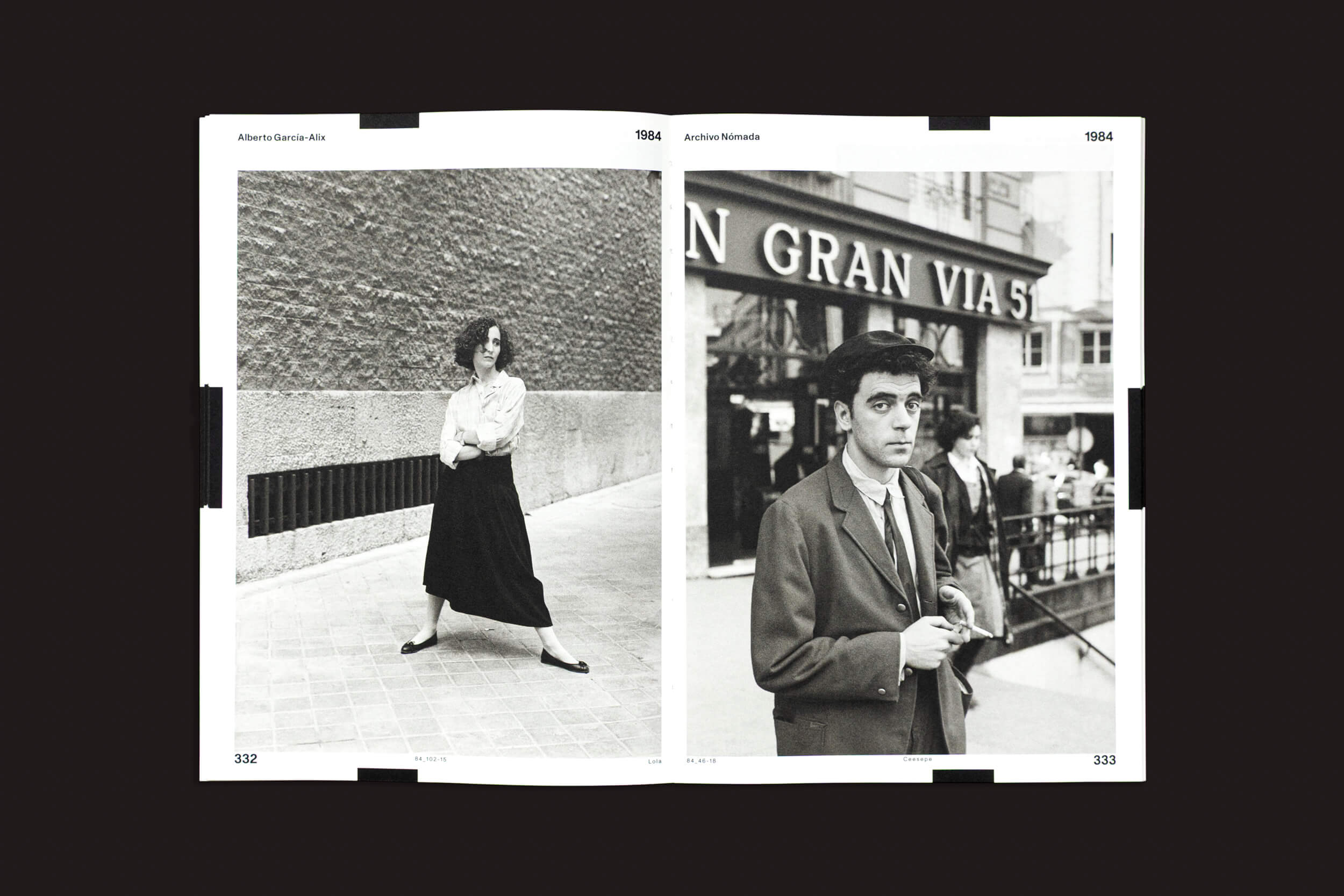 O livro aberto "Alberto García-Alix: Arquivo Nômade 02", de Cabeza de Chorlito, exibe fotos em preto e branco. À esquerda: uma pessoa posa perto de um muro de pedra ao ar livre. À direita: capturando a essência de La Movida, um indivíduo de terno está em pé ao lado da entrada do metrô Gran Vía, em uma rua movimentada.