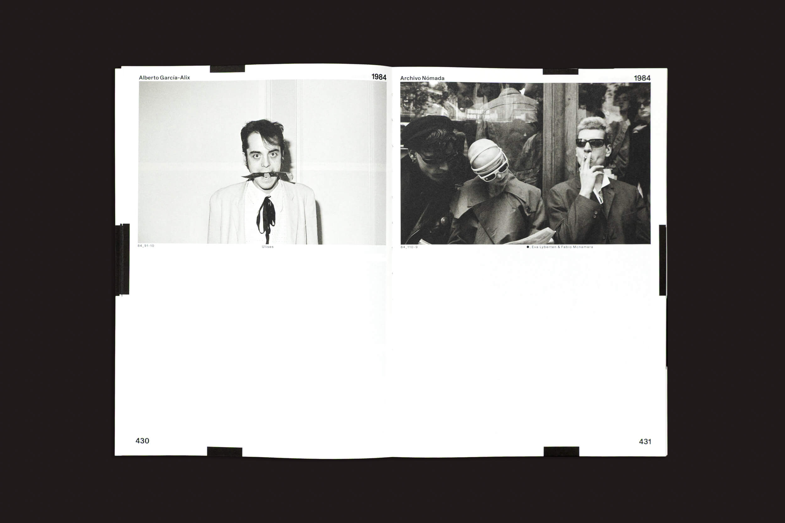 Duas fotos em preto e branco estão abertas no livro "Alberto García-Alix: Arquivo Nômade 02", de Cabeza de Chorlito. À esquerda: Um homem de bigode, de terno, contra um fundo simples. À direita: Era pós-Franco, duas figuras com óculos escuros e jaquetas estão do lado de fora, com reflexos brilhando no vidro atrás delas.