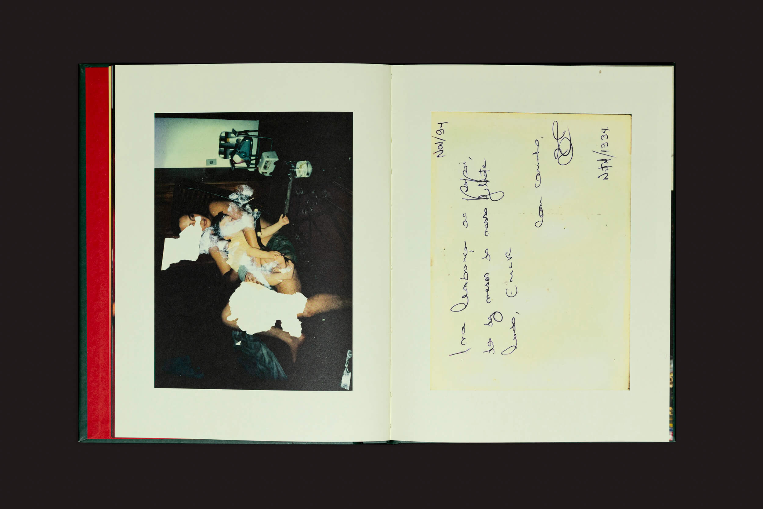 Um fotolivro aberto do Selo Turvo mostra uma foto borrada à esquerda e uma nota manuscrita de Erick Peres à direita, proporcionando um vislumbre da memória familiar. A assinatura e a data completam esta cena intimista ambientada em um cenário sombrio em O choro pode durar uma noite, mas a alegria vem pela manhã.