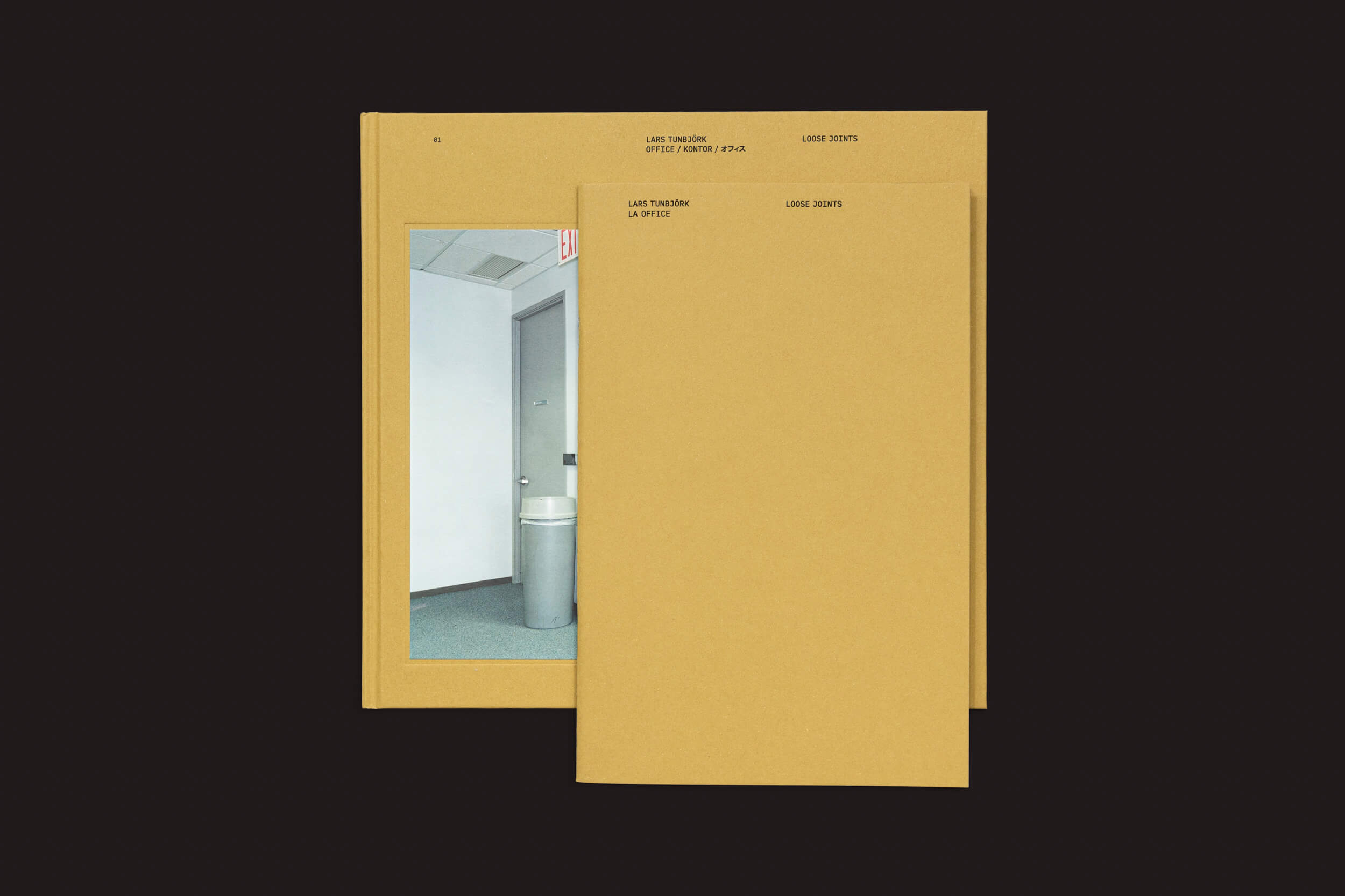 Dois livros amarelo-mostarda intitulados Large Sketch Saffron (Color) e Large Sketch estão empilhados. O livro de cima se sobrepõe ao de baixo, que é Lars Tunbjörk: Office / LA Office de Loose Joints, apresentando uma imagem de capa de um canto de corredor de escritório com uma parede, porta e lata de lixo que lembra o trabalho de Tunbjörk.