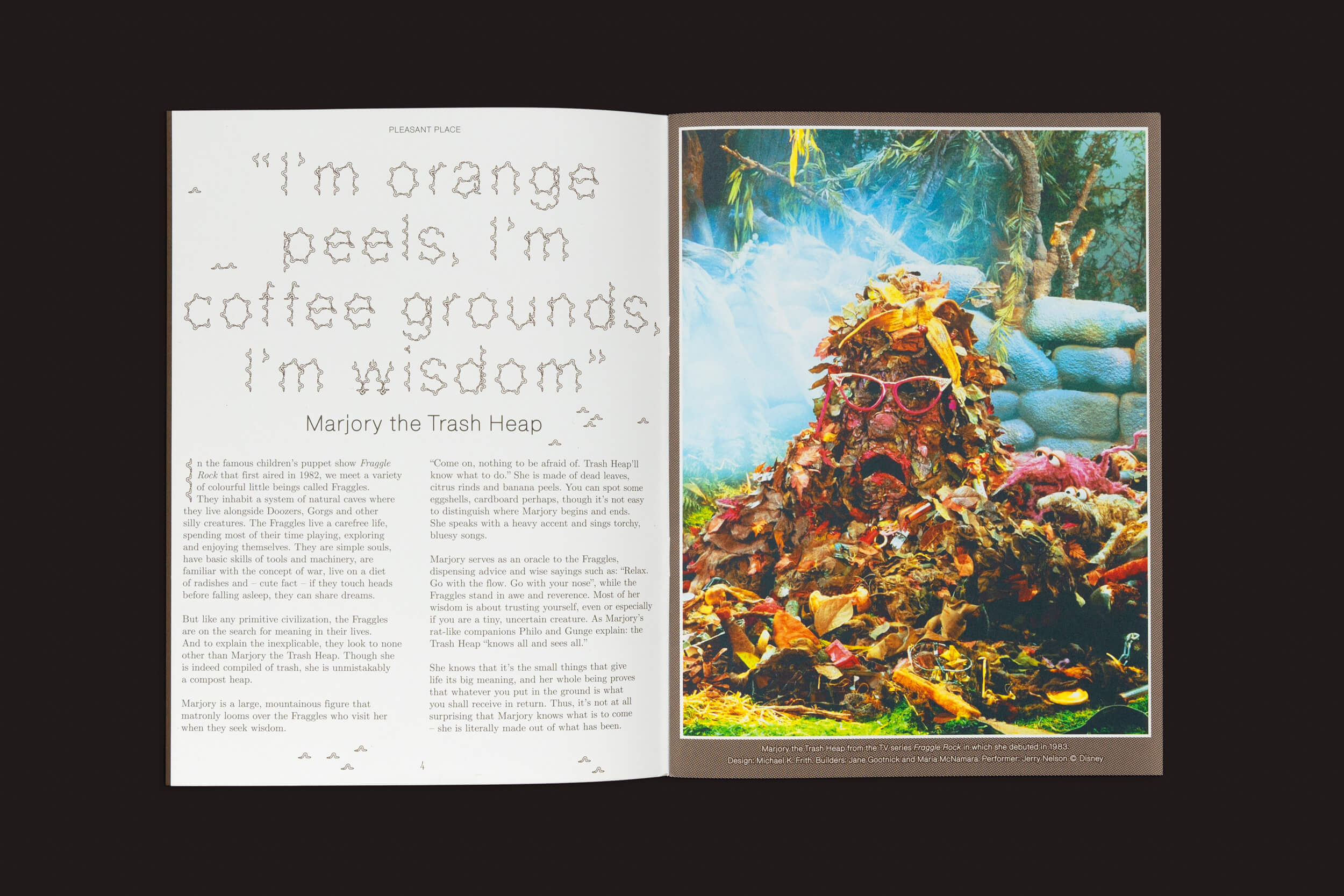 Uma revista aberta apresenta Pleasant Place 3: Compost by Pleasant Place, com uma citação de Marjory the Trash Heap sobre lixo ao lado de uma imagem de lixo vibrante e caprichoso, sugerindo compostagem de jardim.