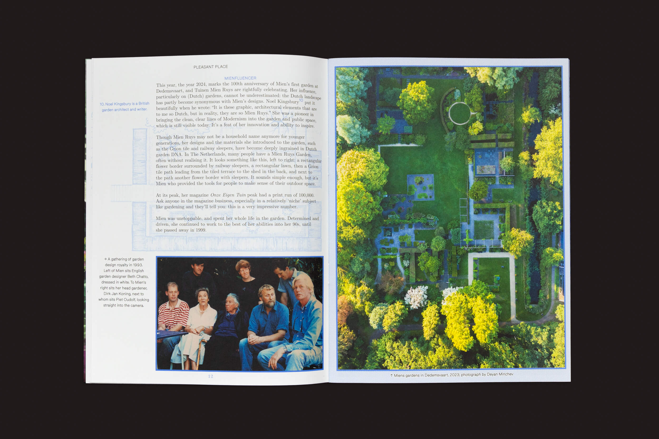 Uma revista aberta revela uma página esquerda com texto e uma pequena foto de pessoas reunidas. À direita, uma vista aérea se desdobra, exibindo um jardim exuberante projetado no estilo de Pleasant Place 5: Mien Ruys da Pleasant Place, apresentando caminhos estruturados e árvores vibrantes inspiradas nos princípios do Movimento das Novas Perenes.