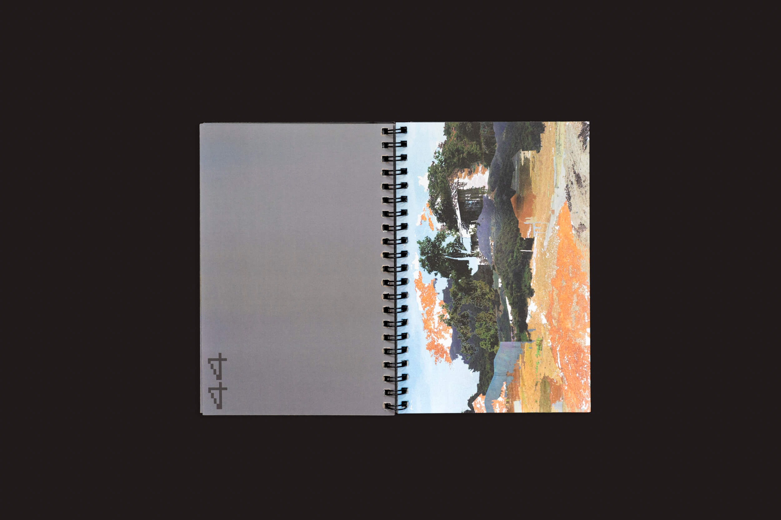 Um livro aberto encadernado em espiral, Romeu Silveira: Post-Paysages da zero-Edições, repousa sobre um fundo preto. A página da direita exibe uma paisagem abstrata semelhante ao Google Street View com tons terrosos, enquanto a da esquerda é majoritariamente cinza com texto preto mínimo no canto sugerindo colagens digitais.