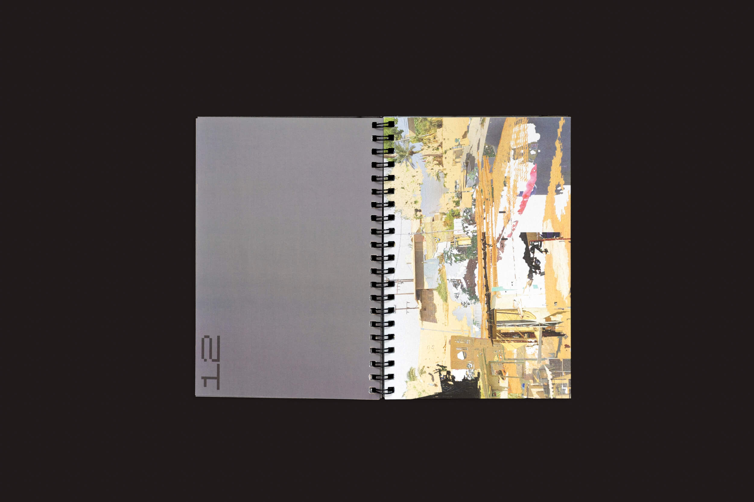 Um caderno aberto com espiral da coleção Romeu Silveira: Post-Paysages da zero-Edições está sobre um fundo preto. A página da esquerda é cinza com 12 na parte inferior, e a da direita exibe obras de arte abstratas e coloridas inspiradas em colagens digitais em tons terrosos.