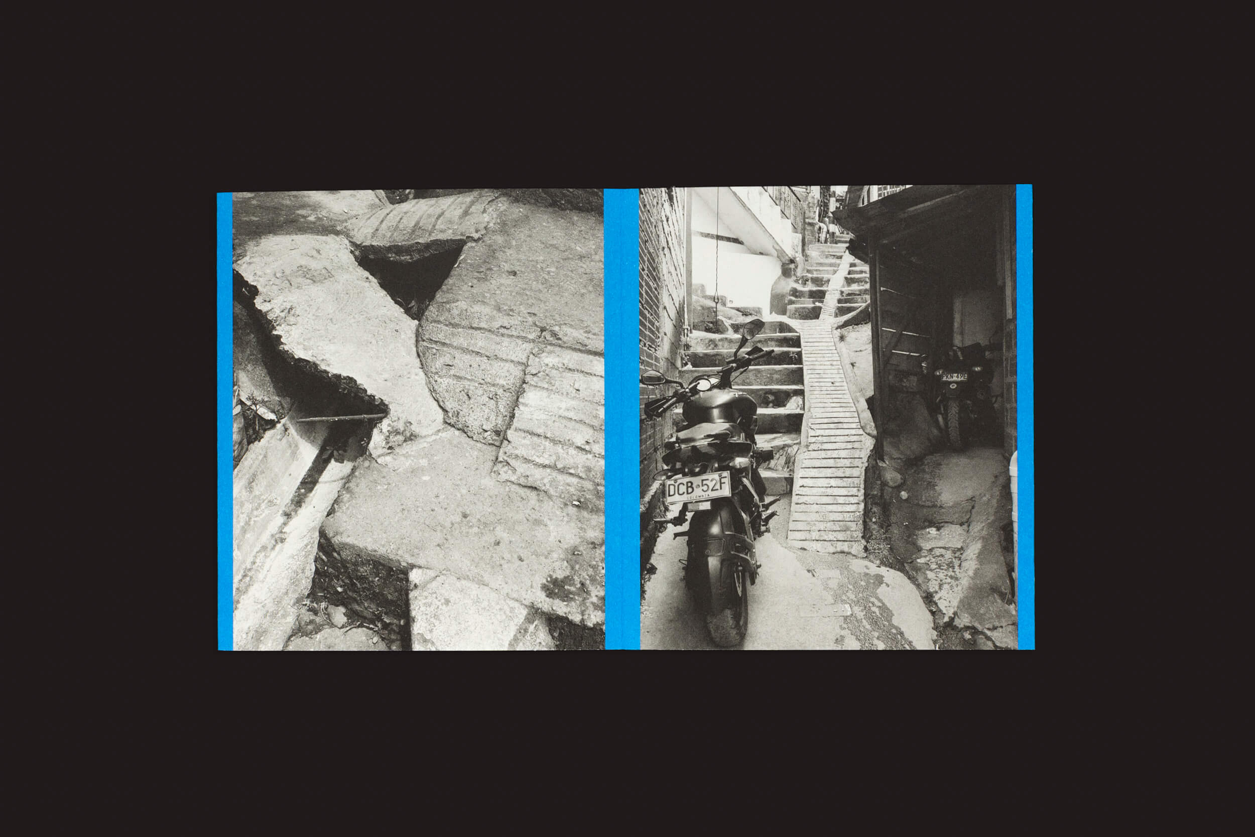 Thomas Locke Hobbs: Rampitas, do Eriskay Connection, contrasta artisticamente o brutalismo popular com lajes de concreto quebradas à esquerda e uma motocicleta estacionada ao lado de uma escada íngreme em um caminho estreito e irregular à direita, separados por faixas azuis.