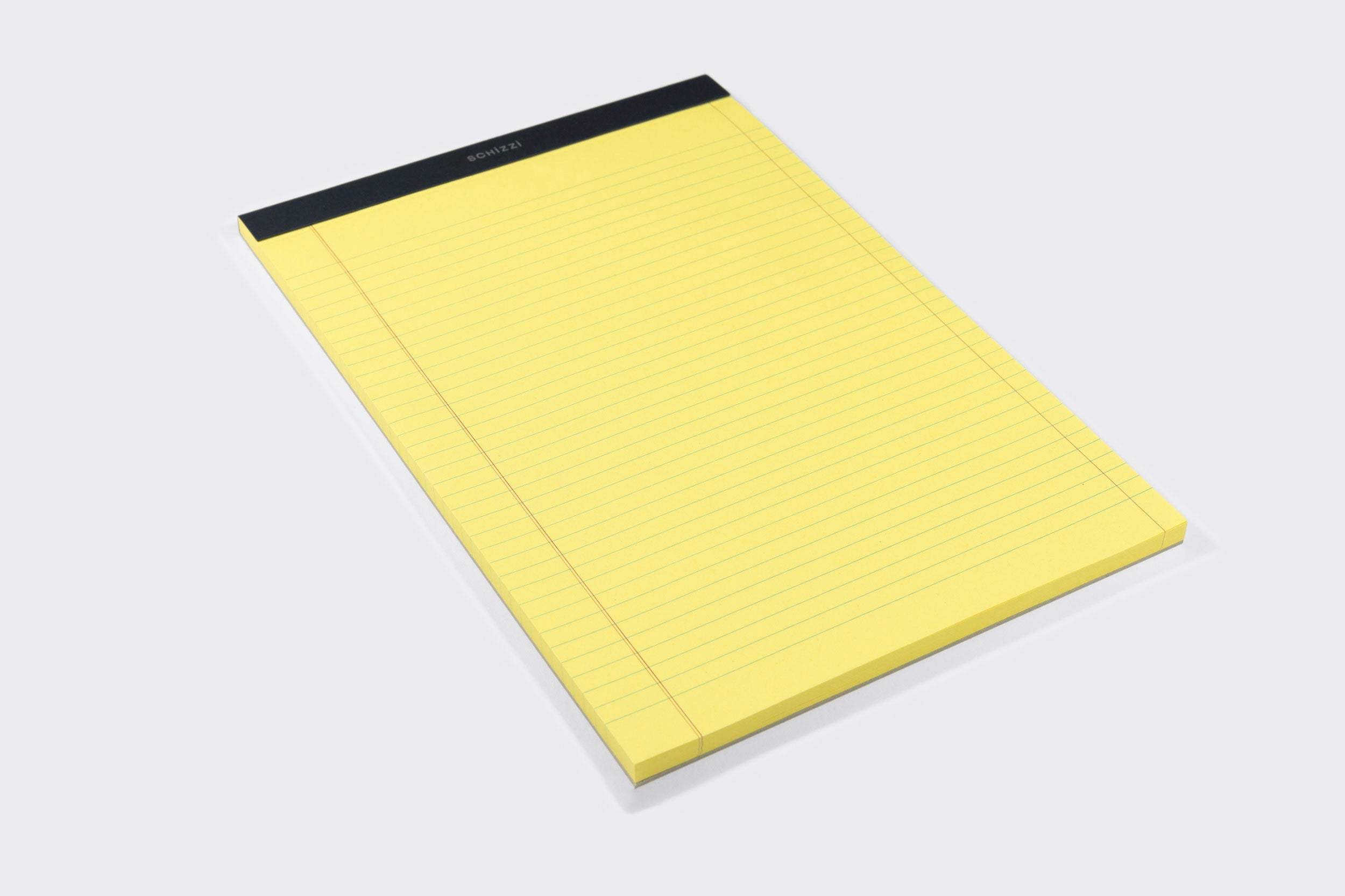 O Bloco Amarelo: A4 da Schizzibooks, com papel amarelo pautado e encadernação preta superior, feito no Brasil, é apoiado sobre uma superfície clara.