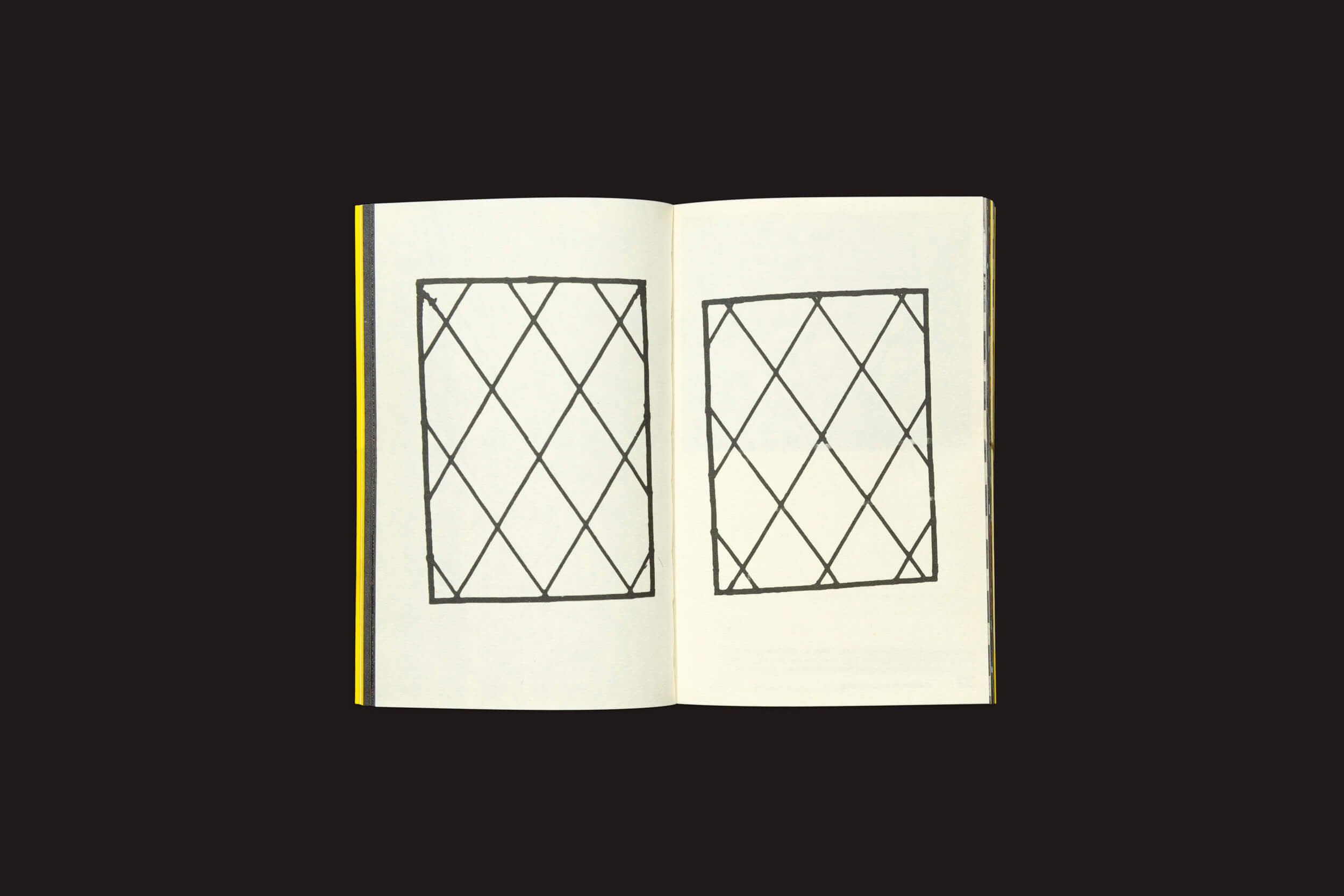 O livro aberto, Ermãos Monjon: Sinais/Signs da Livros Fantasma, revela páginas com desenhos geométricos como retângulos de treliça sobre um fundo preto. A lombada fica à esquerda, sugerindo contos artísticos.