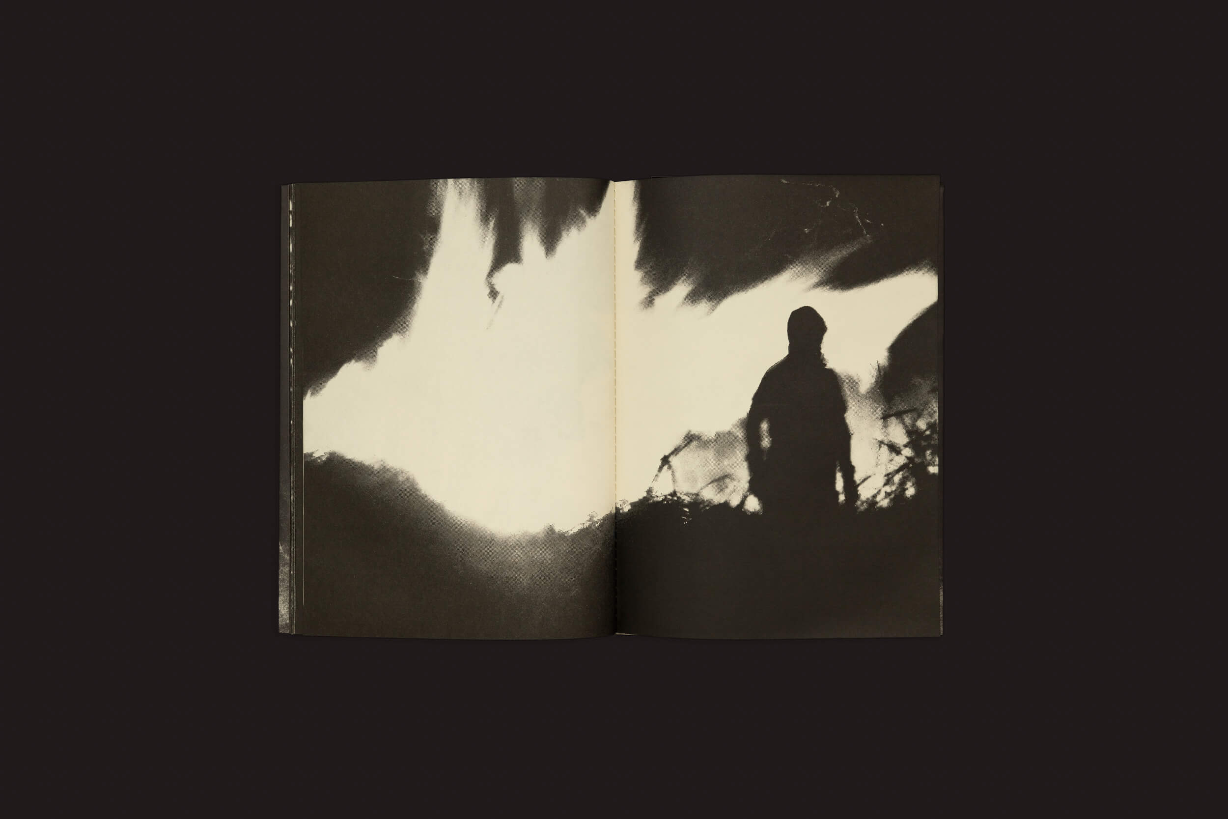 Uma página de Sintomas: Vários Artistas de Selo Turvo mostra uma imagem em preto e branco de alto contraste de uma silhueta em um vilarejo, contra um fundo abstrato, criando um efeito dramático.