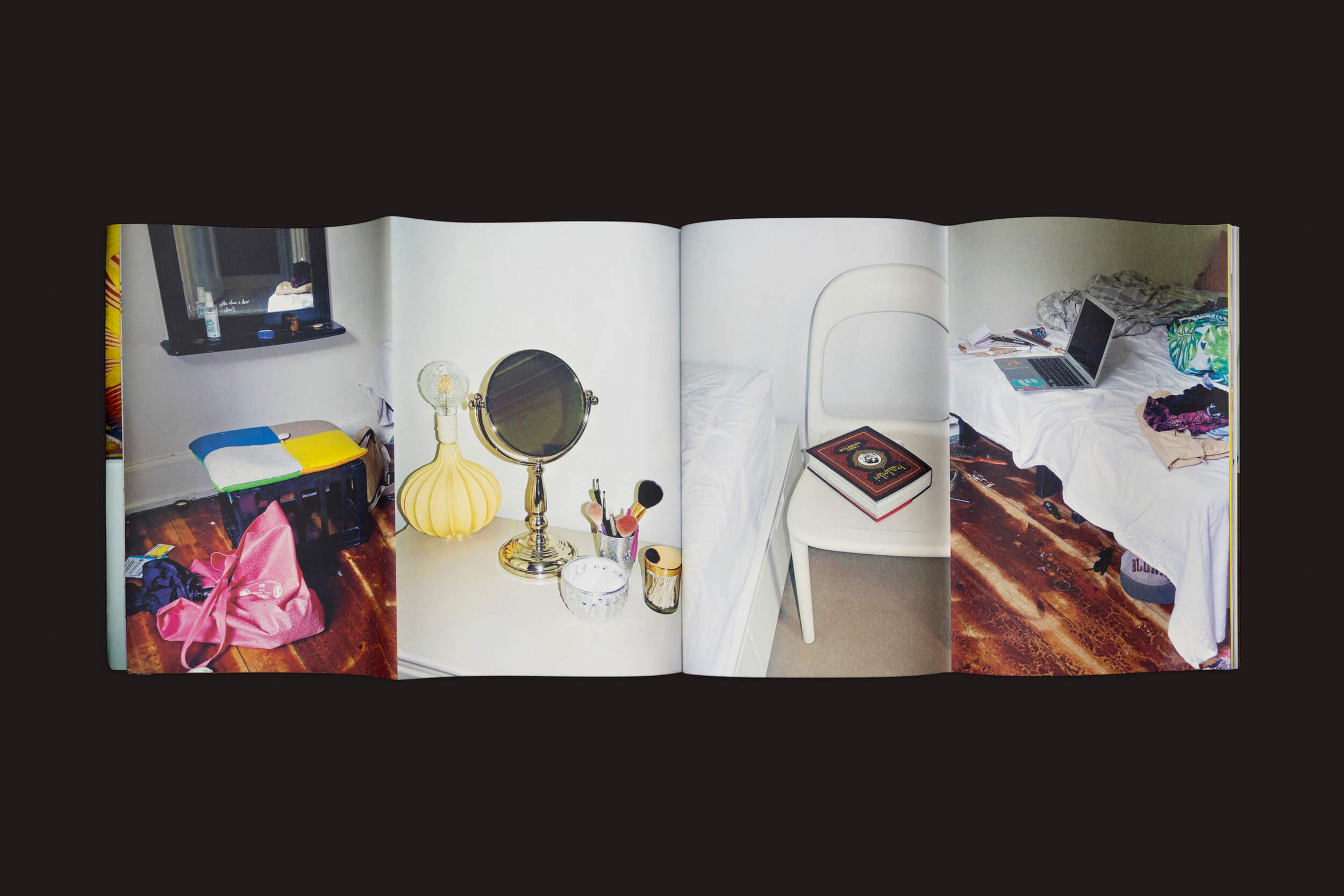 Uma foto de revista aberta mostra um quarto desorganizado refletindo a cultura jovem dinamarquesa da obra Natureza Morta de Adolescentes, de Barbara Marstrand, de Disko Bay, com um banco colorido, penteadeira com maquiagem, livro na cadeira, laptop na cama e itens variados no piso de madeira.