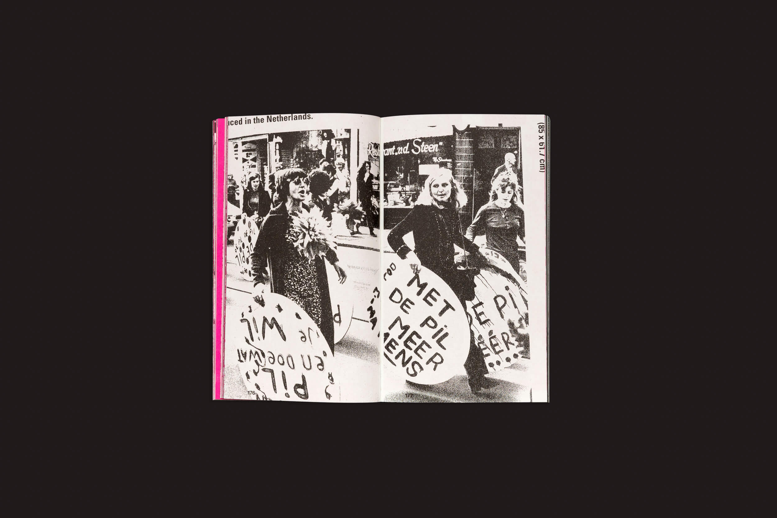 Em uma foto em preto e branco de Experimental Jetset: Superstructures (Notes On Experimental Jetset / Volume 2) da Roma Publications, um livro aberto exibe uma cena de protesto com placas circulares em holandês. O cabeçalho diz The pill in the Netherlands com números de página nos cantos superiores, refletindo uma vibe pós-punk.