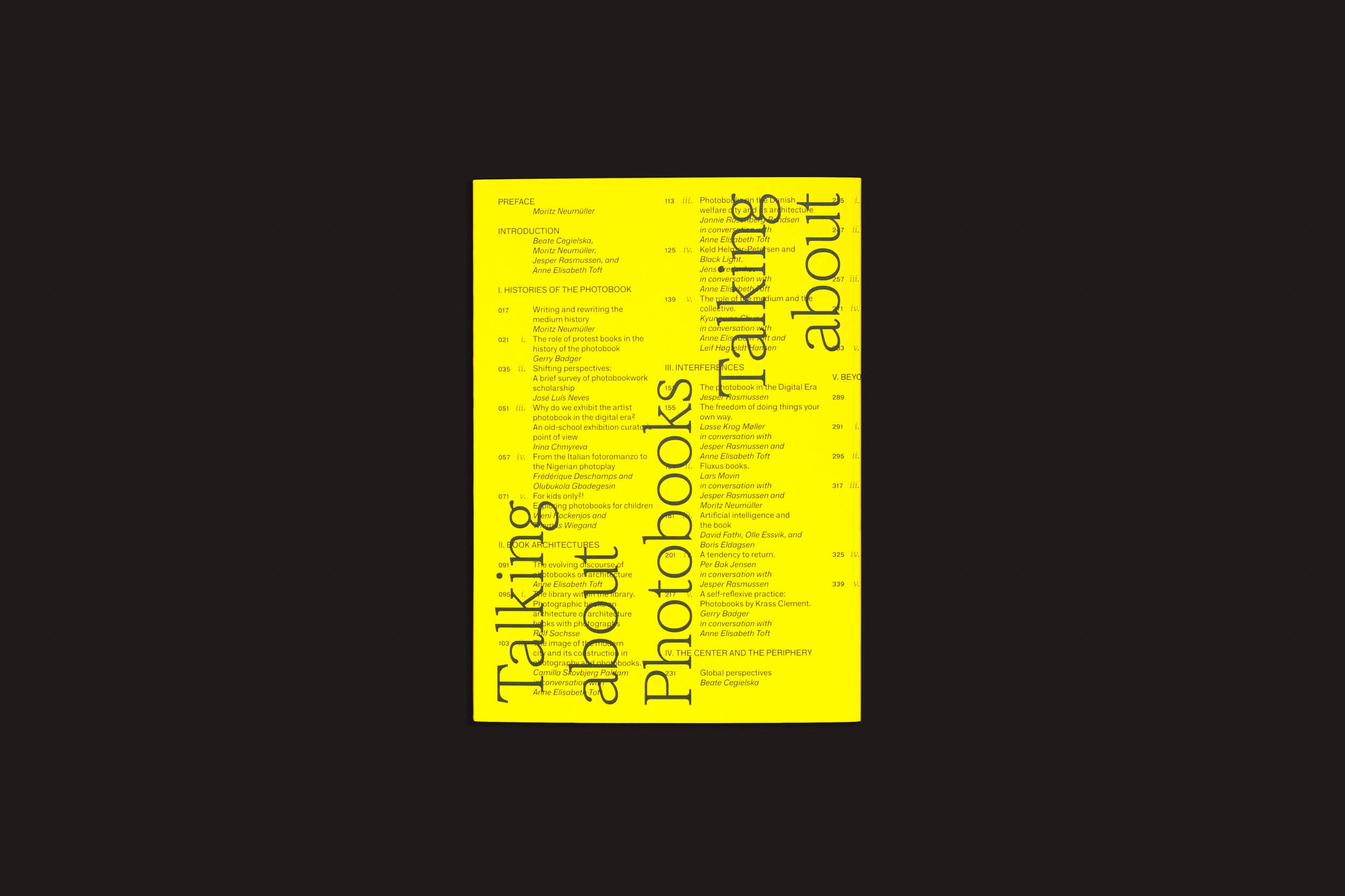 Uma capa de livro amarelo brilhante com texto preto em negrito apresenta o título "Talking About Photobooks: Moritz Neumüller" girado verticalmente à esquerda, explorando "história do fotolivro". A direita lista os conteúdos, integrando temas de arte e sociedade em um fundo preto suave. Marca: Fw:Books.