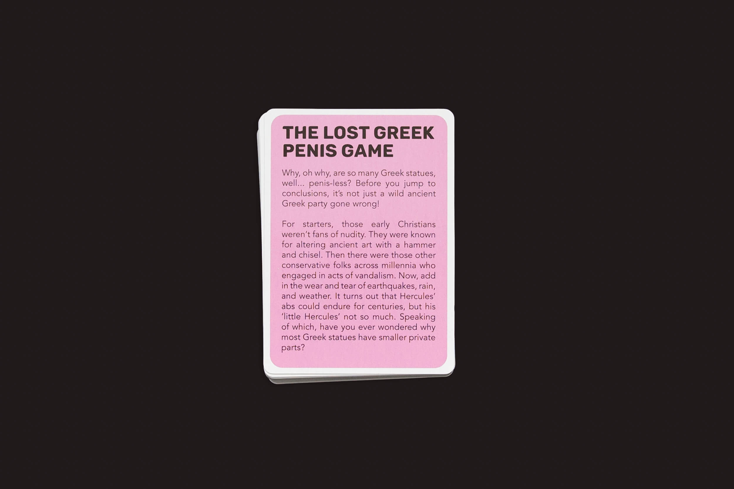 Um card do The Lost Greek Penis Game da Fraglich Publishing, em um cenário preto, explora com humor o motivo pelo qual as estátuas gregas têm pênis pequenos, conectando-o à cultura antiga e aos jogos com Hércules. Este jogo colorido distorce de forma lúdica os mistérios das estátuas gregas.