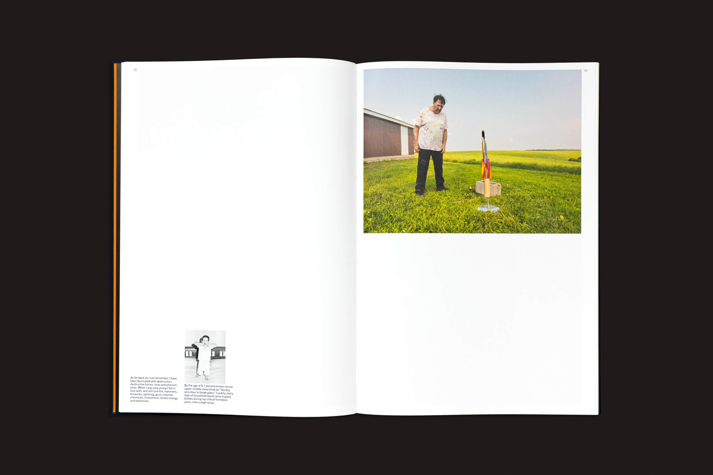 O livro aberto revela a foto de uma pessoa na grama, observando um foguete em um suporte de madeira, ecoando o estilo de Kevin Cooley. Em frente, em preto e branco, uma imagem e um texto acompanham a cena em meio a prédios e campos. Produto: Kevin Cooley: The Wizard of Awe, de The Eriskay Connection.