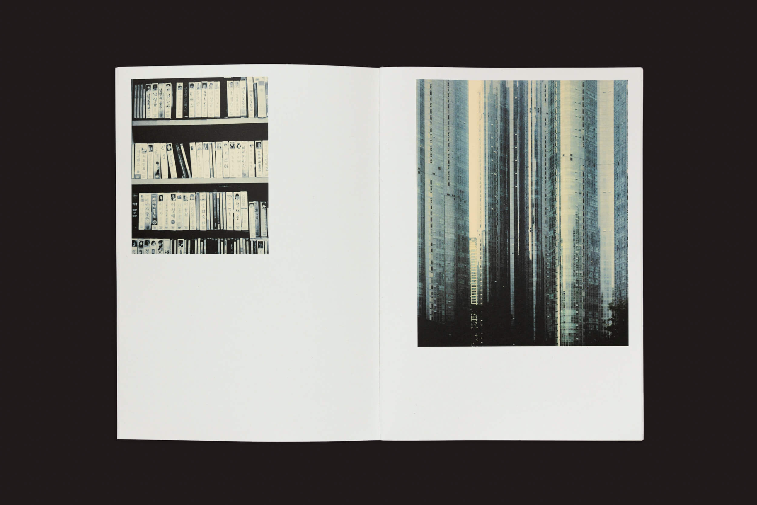 O livro aberto, Eduard Sánchez Ribot: Tierra, Camino, Fruto, da Handshake, exibe na página esquerda imagens de estante em preto e branco que lembram um caminho moderno e na página direita uma grande foto de arranha-céus altos em um padrão de grade, ambos com um design minimalista.