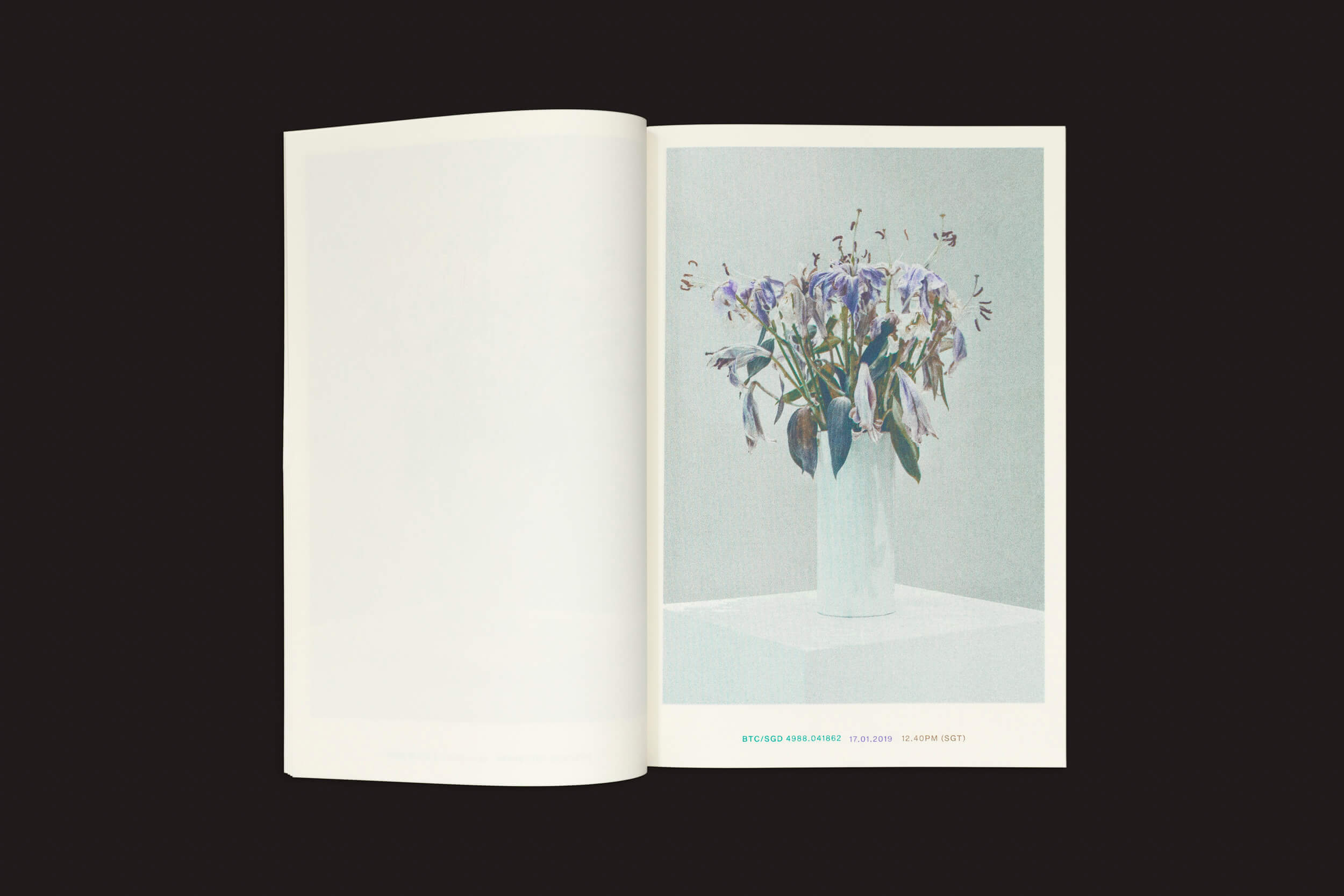 Abra uma página de Xavier Antin: Vanishing Workflows, da Temporary Press, com uma foto de um vaso branco com flores roxas murchas sobre uma mesa, simbolizando a mistura de tecnologia e natureza, enquanto a página oposta permanece em branco contra um fundo preto sólido.