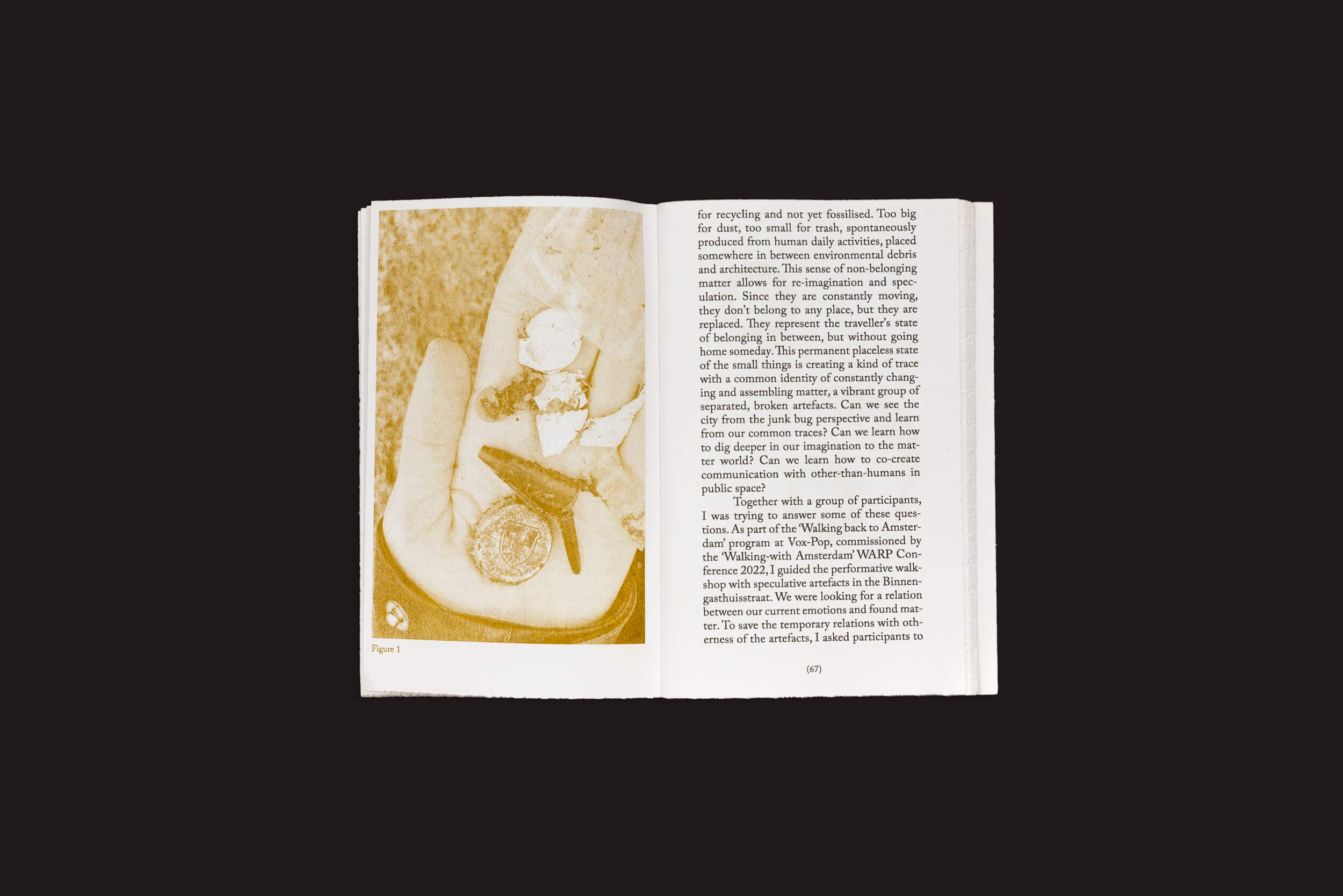 Um livro aberto intitulado Alice Twemlow, Tânia A. Cardoso: Walking as Research Practice da Roma Publications repousa sobre uma superfície escura. A página da direita mostra texto em colunas, enquanto a da esquerda apresenta uma imagem em tom sépia de uma cadeira com objetos, evocando um senso de investigação em espaços urbanos.