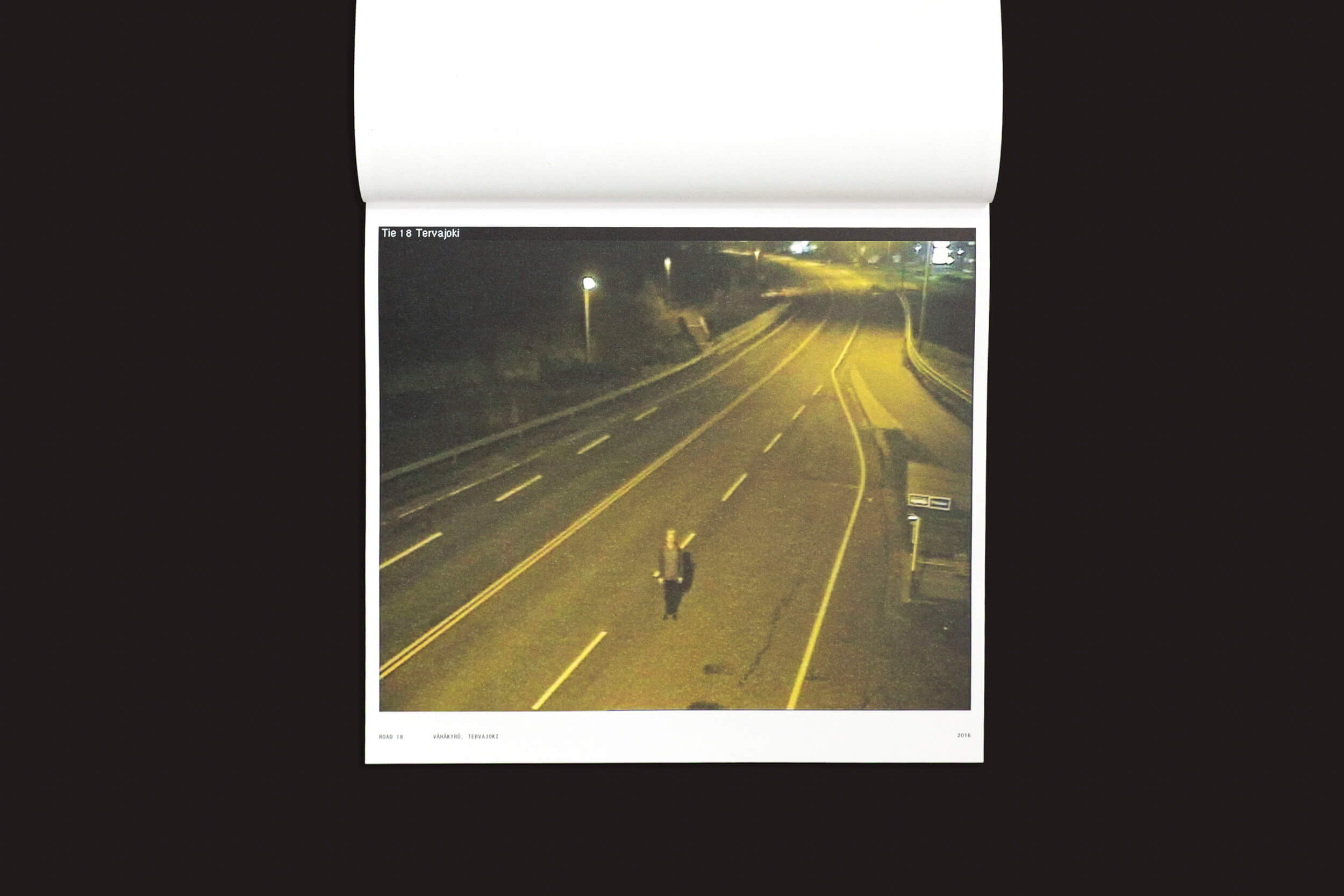 Sob o brilho assustador dos postes de luz em uma estrada de duas pistas deserta e mal iluminada à noite, Tatu Gustafsson captura autorretratos impressionantes para "I on the Road / Weather Camera Self-Portraits, 2012-2021", um livro da Fw:Books. O ambiente tranquilo não tem veículos ou pessoas, perfeito para esse tipo de fotografia.