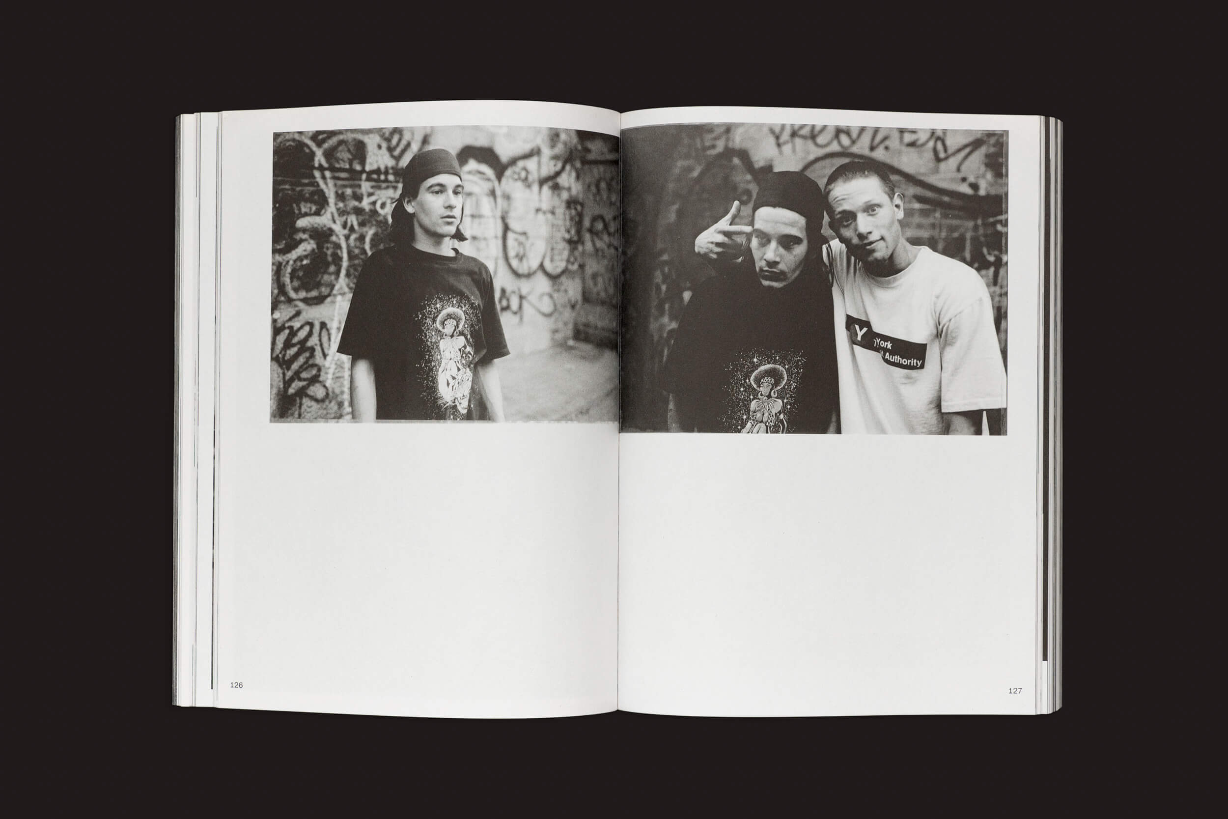 Em Ari Marcopoulos: Beware da Roma Publications, um livro aberto exibe duas fotos em preto e branco: três jovens em trajes casuais e bonés estão diante de um muro de grafite. A página da esquerda mostra dois indivíduos, capturando a essência da cidade por meio de sacolas marrons ou skatistas em Nova York.