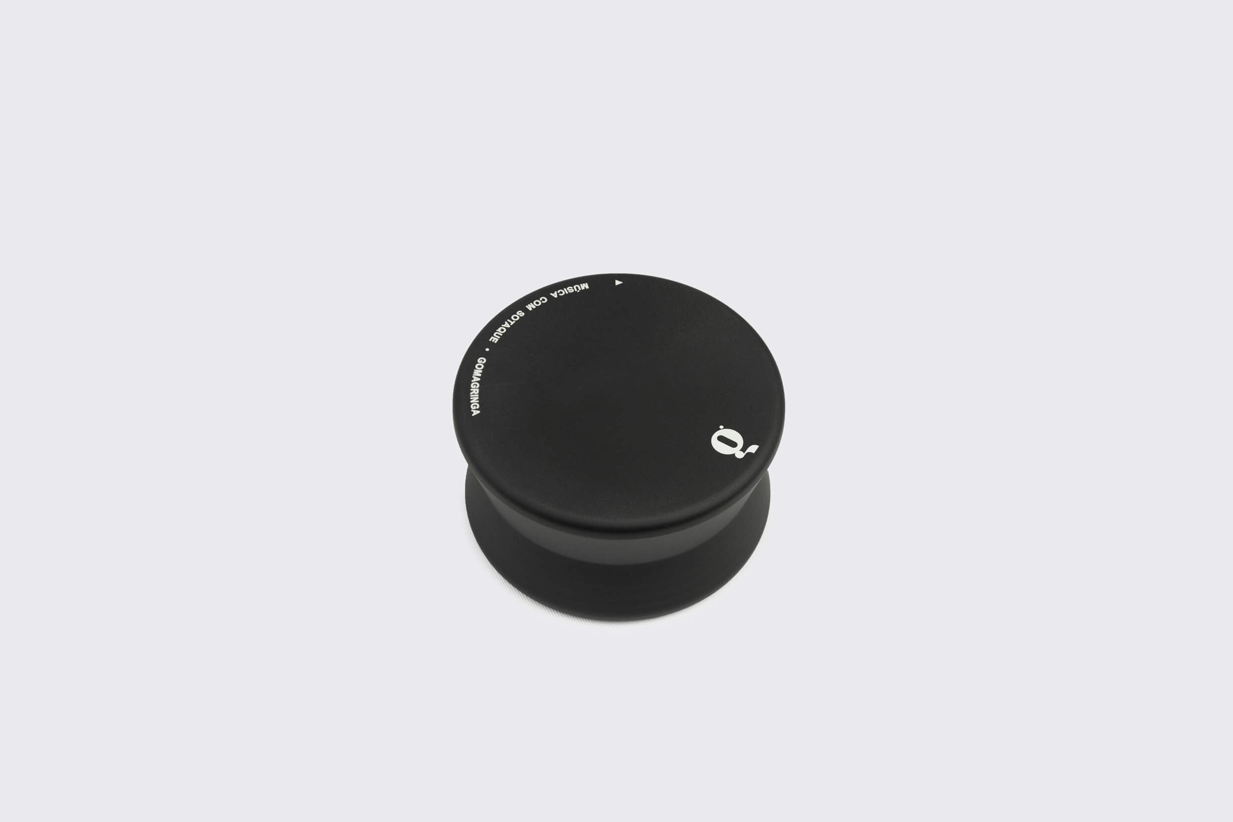 O Estabilizador de Disco Goma Gringa: Modelo B é um elegante ioiô preto com um pequeno logotipo branco, feito de alumínio anodizado, elegantemente exibido em um fundo branco simples.