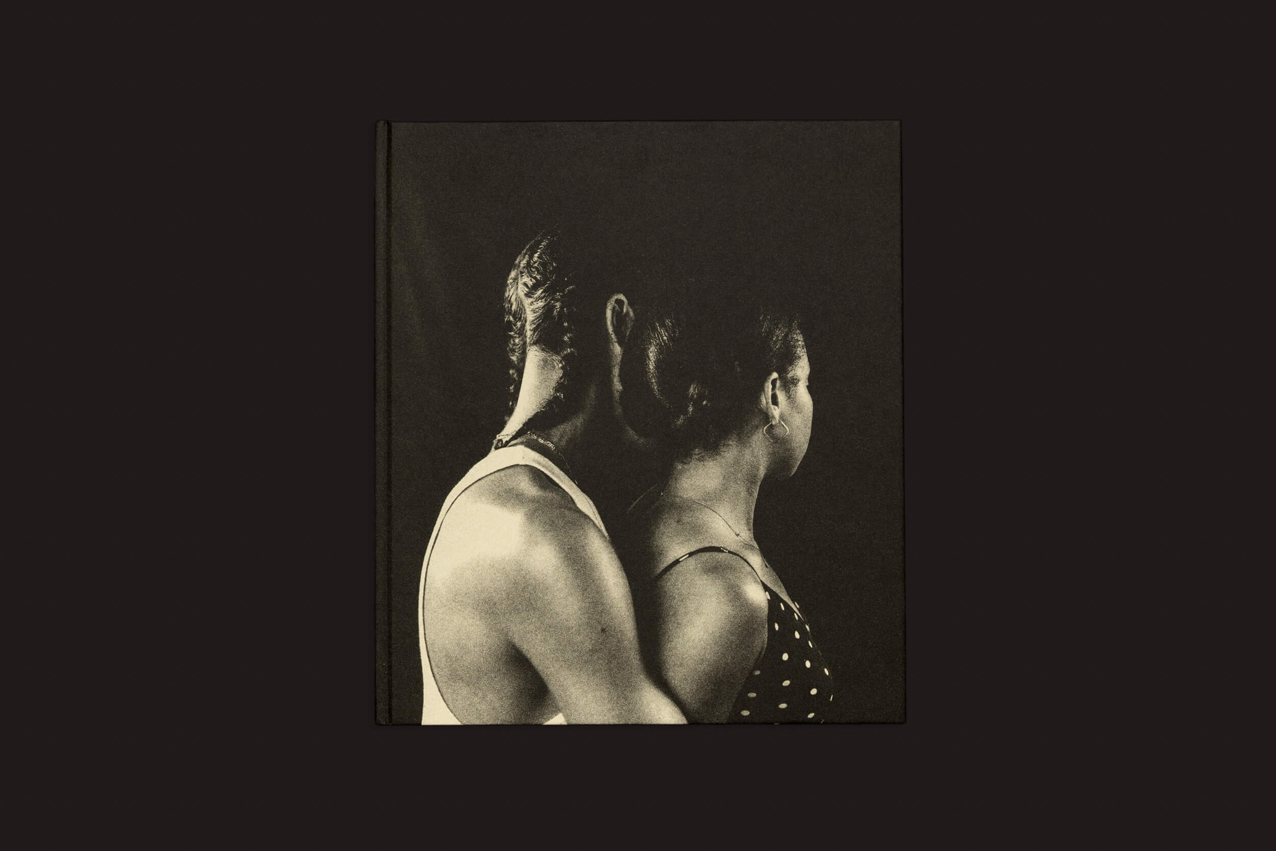 I Cant Stand to See You Cry de Rahim Fortune em tom sépia por Loose Joints captura duas pessoas costas com costas contra um fundo escuro. Uma identidade intrigante é evocada quando a figura da esquerda usa um top claro, e a da direita veste bolinhas, ambas olhando para longe da lente.