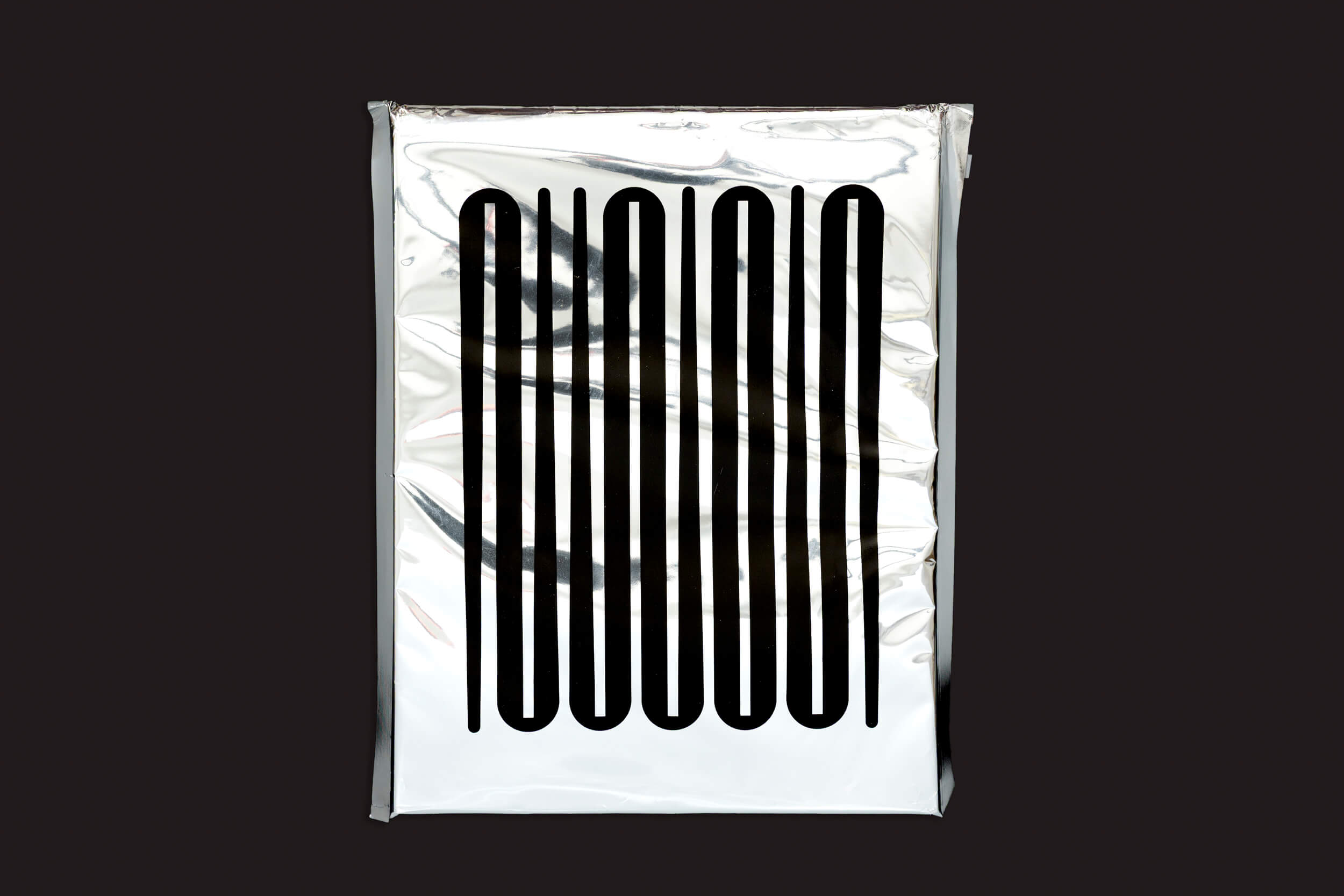 Uma elegante embalagem retangular prateada com linhas pretas verticais abstratas na frente se destaca contra um fundo escuro, evocando o charme futurista de "Ezio D'Agostino: NEOS" de Skinnerboox e o conceito de mineração de asteroides.