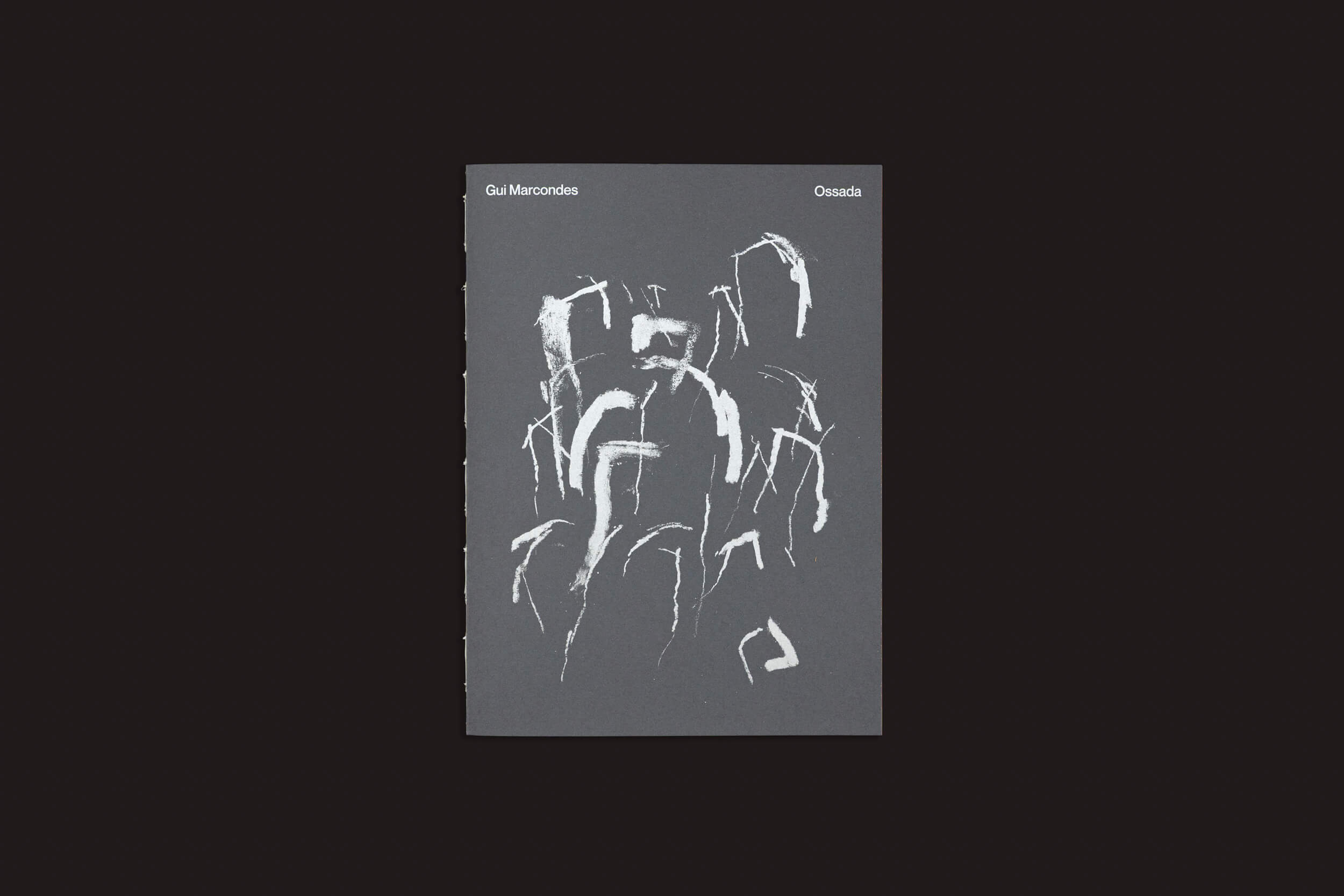 A capa cinza escuro de Gui Marcondes: Ossada, de Selo Turvo, traz desenhos abstratos de linhas brancas que lembram desenhos em carvão. “Gui Marcondes” está no canto superior esquerdo e o título “Ossada” no canto superior direito.