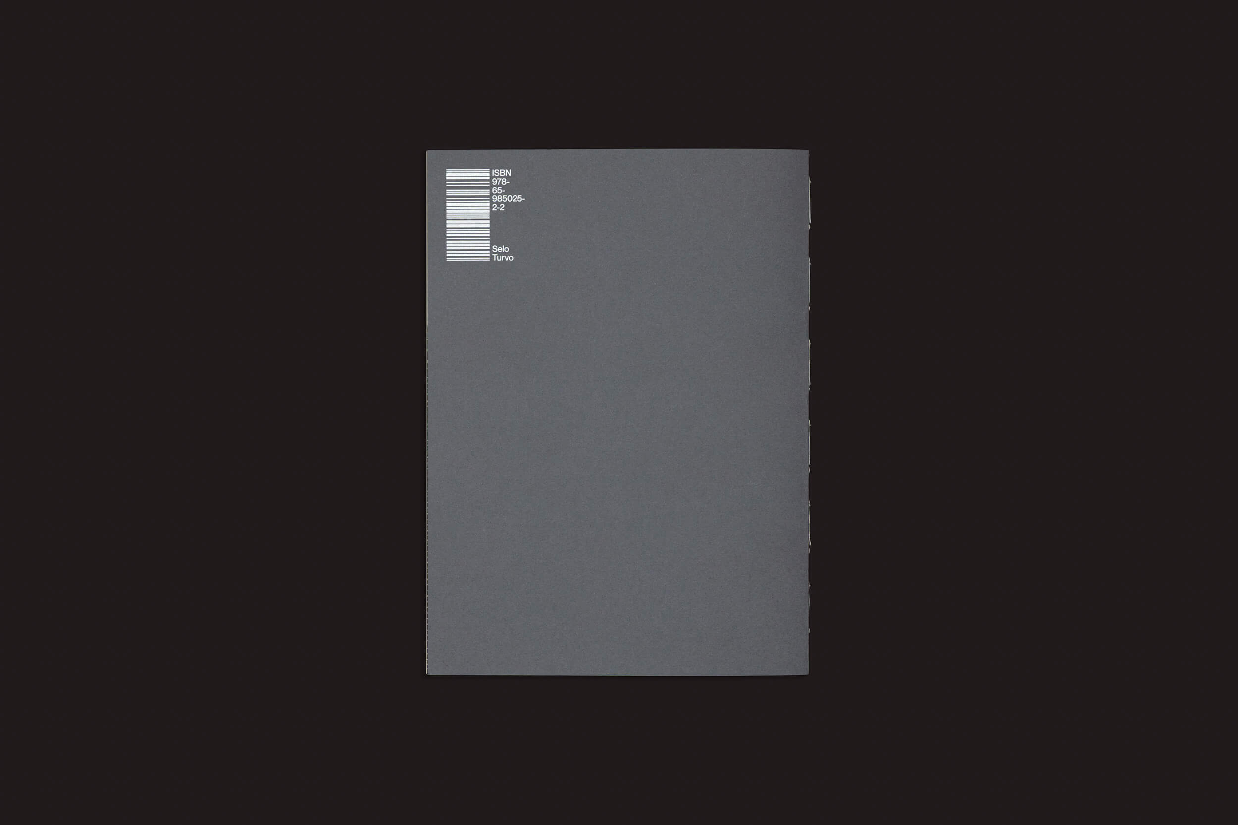 A capa de "Gui Marcondes: Ossada", de Selo Turvo, apresenta um design minimalista, predominantemente preto, com um retângulo cinza central com código de barras e números, incorporando o conceito de caos arquitetado por meio de sua simplicidade e contraste.