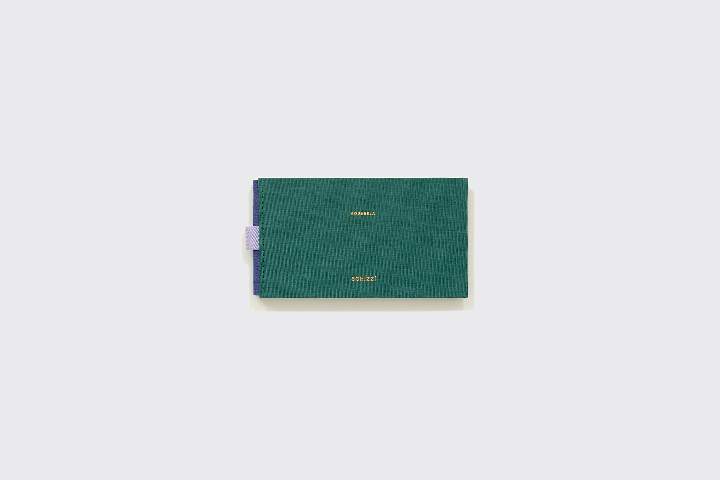 Caderno Aquarela Pocket quadrado, verde, de capa dura, da Schizzibooks, com texto dourado "agenda" e "atelier", papel premium e um porta-canetas lilás à esquerda, sobre um fundo cinza claro simples.