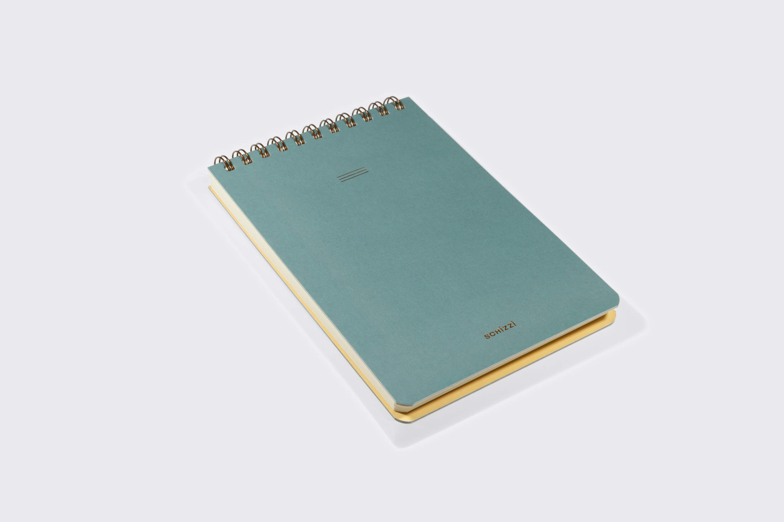 Um caderno azul encadernado em espiral, o Caderno Reporter: Nórdico da Schizzibooks, repousa sobre uma superfície cinza-claro. Suas páginas de cor creme contrastam elegantemente com a encadernação em wire-o bronze. A capa simples apresenta três linhas horizontais e "BONAGE" na parte inferior.